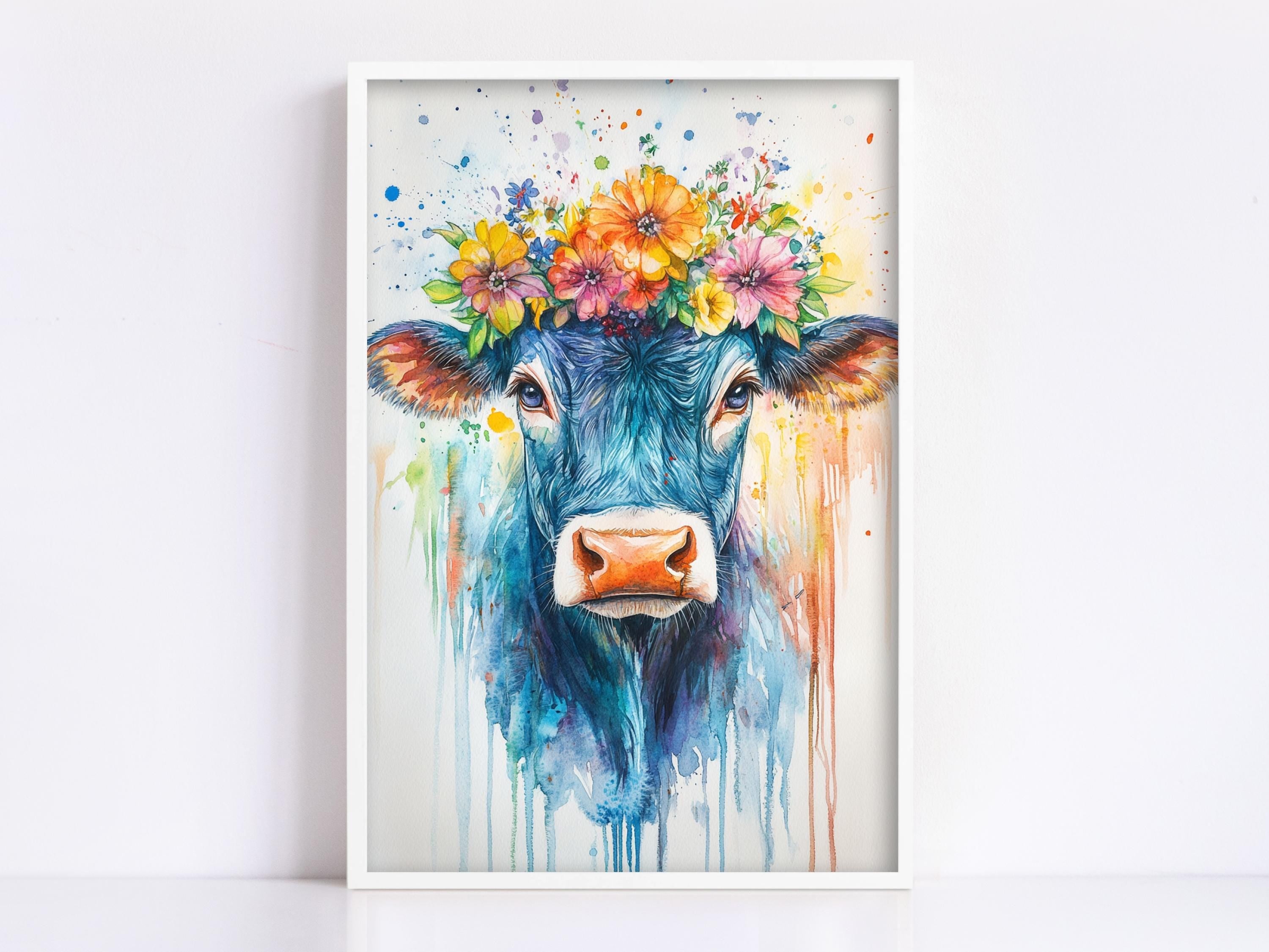 A framed painting depicting a blue cow with a colorful flower crown on its head, surrounded by splashes of color.