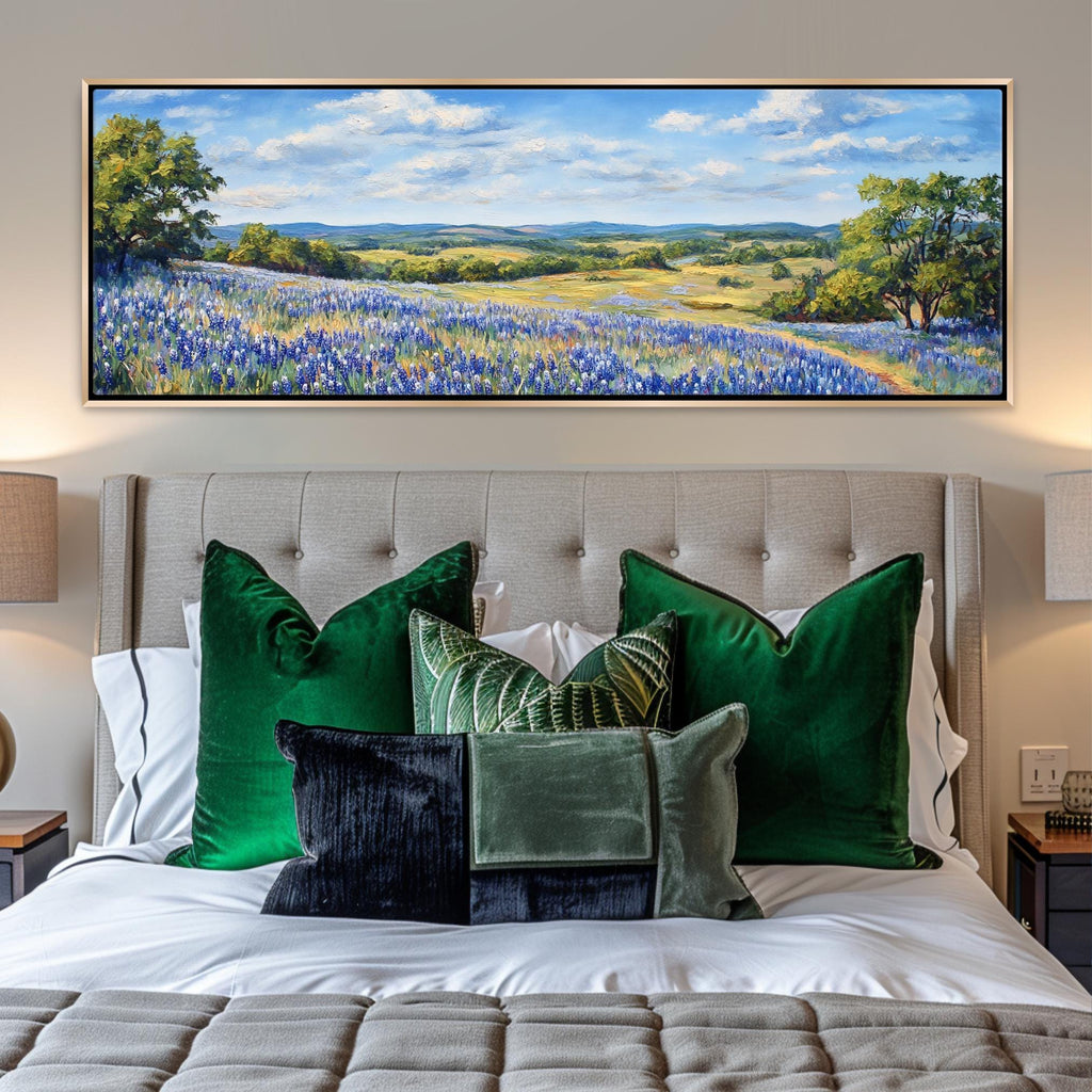 a painting of a field of bluebonnets hangs above a bed