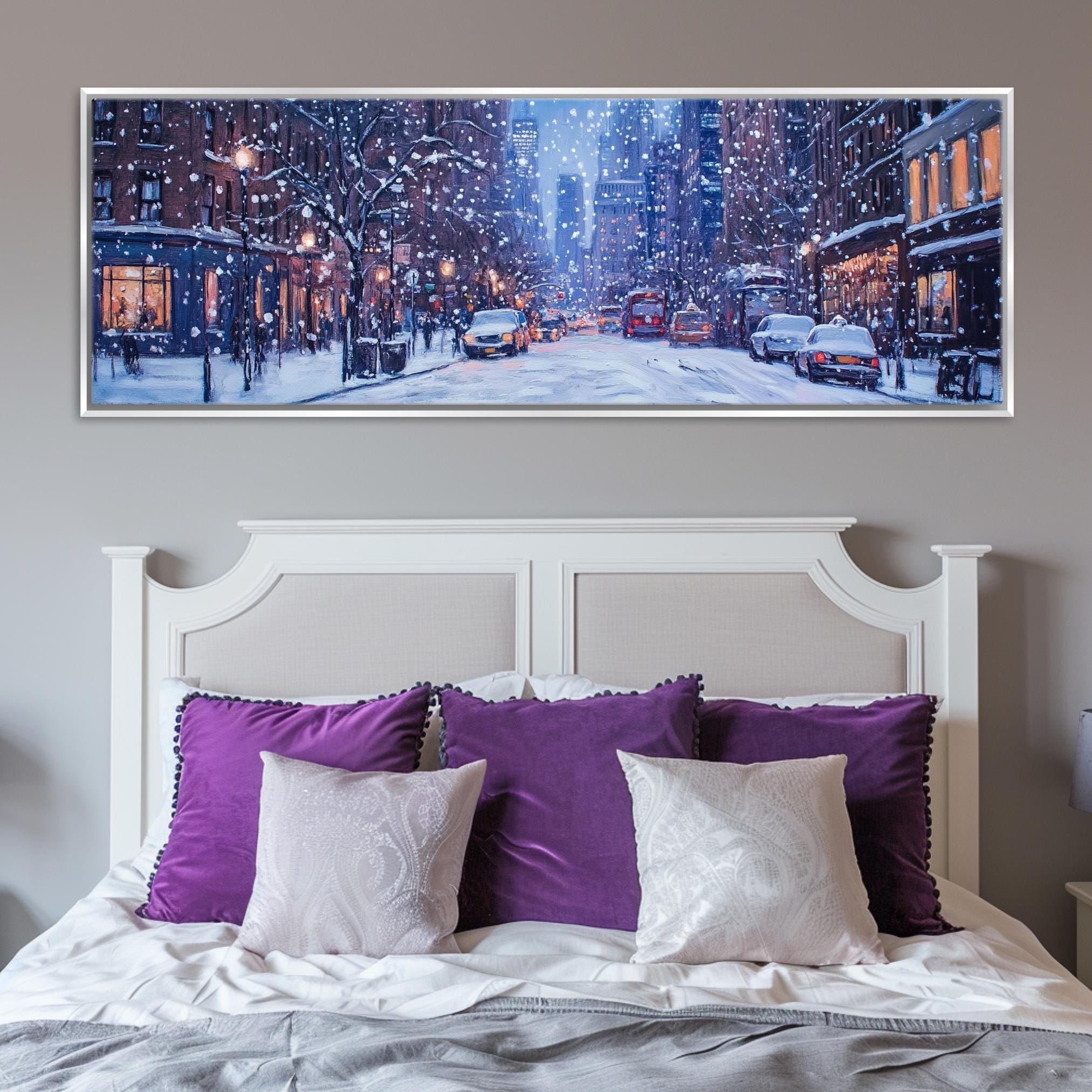 a bed with purple pillows and a picture on the wall above it