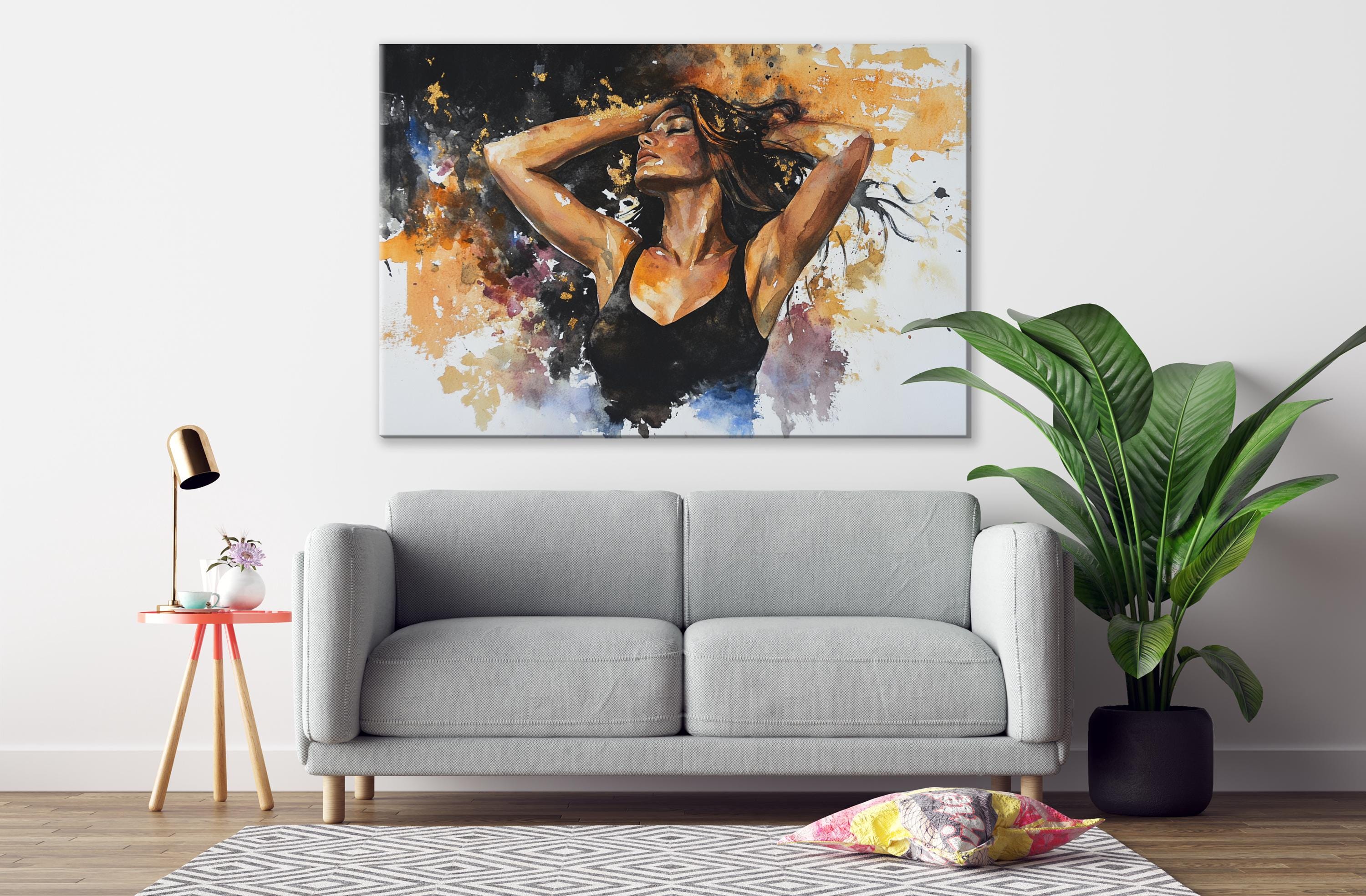 a gray sofa, a potted plant, and a painting of a woman with her arms raised above her head.