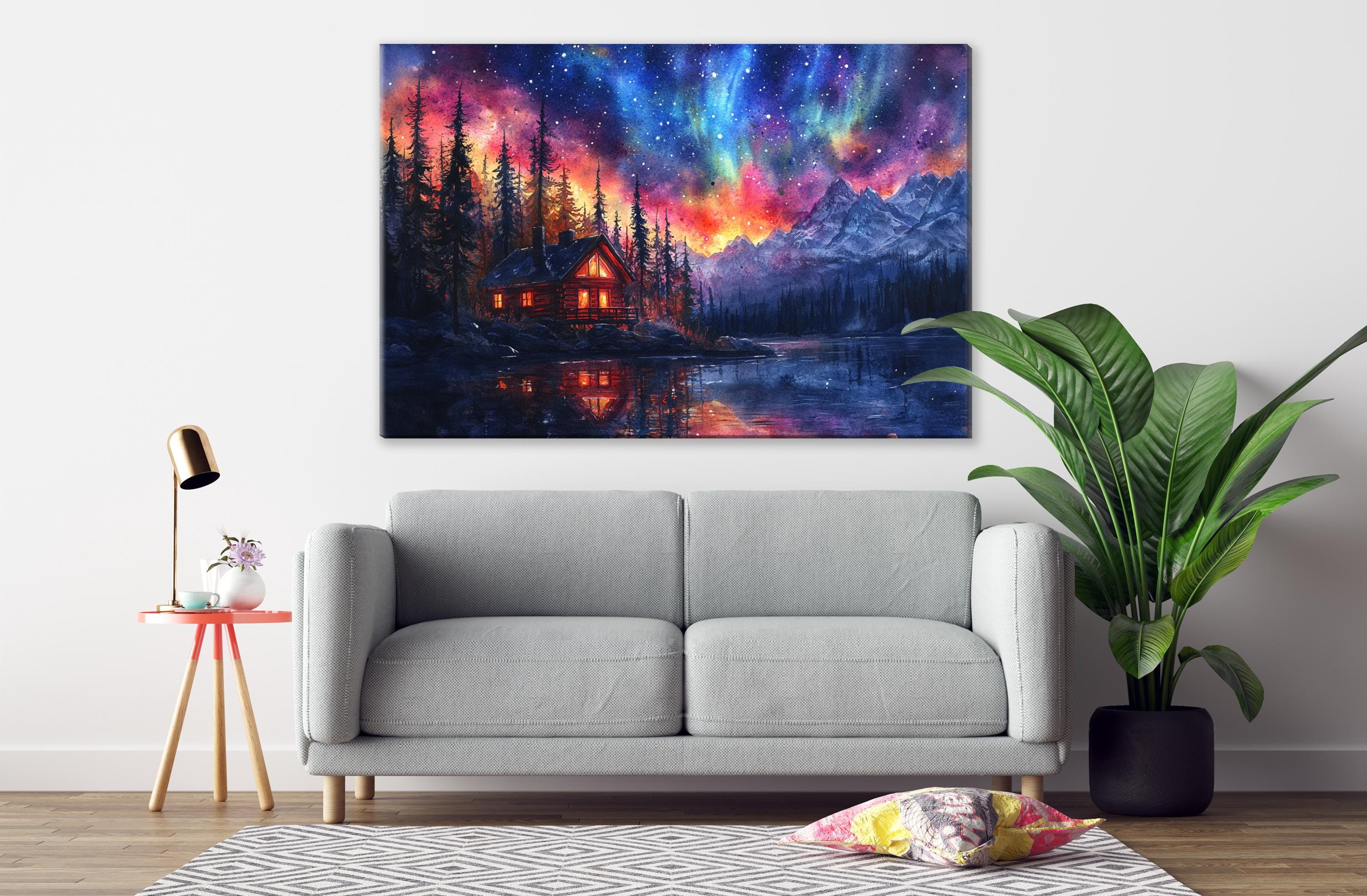 a cozy living room with a gray sofa, a wooden side table with a lamp, and a large painting of a cabin on the wall. The painting depicts a serene mountain landscape with a lake and a starry night sky.