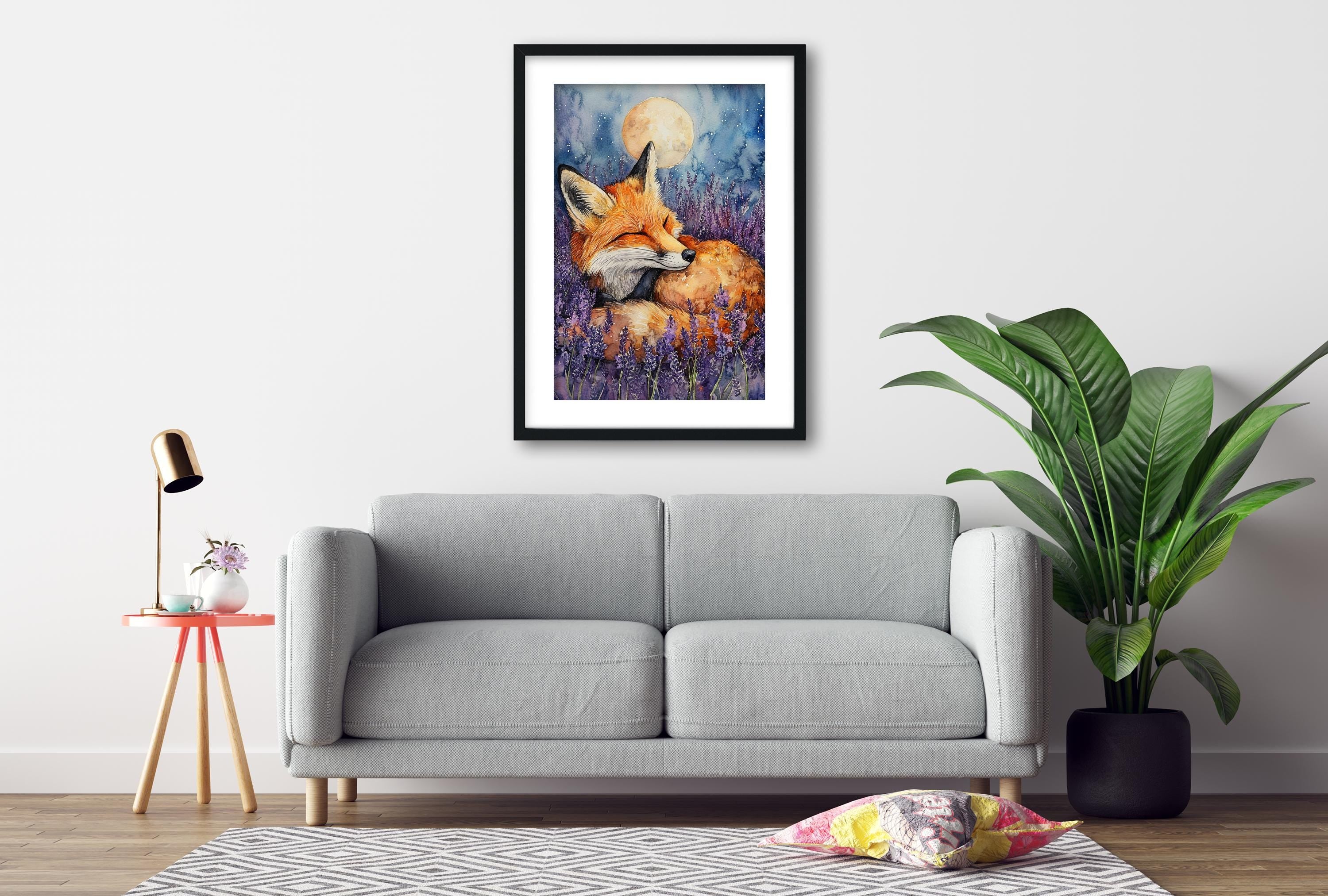 a gray sofa, a framed painting of a fox in a field of flowers, a small table with a lamp, and a potted plant, all arranged in a cozy living room setting.