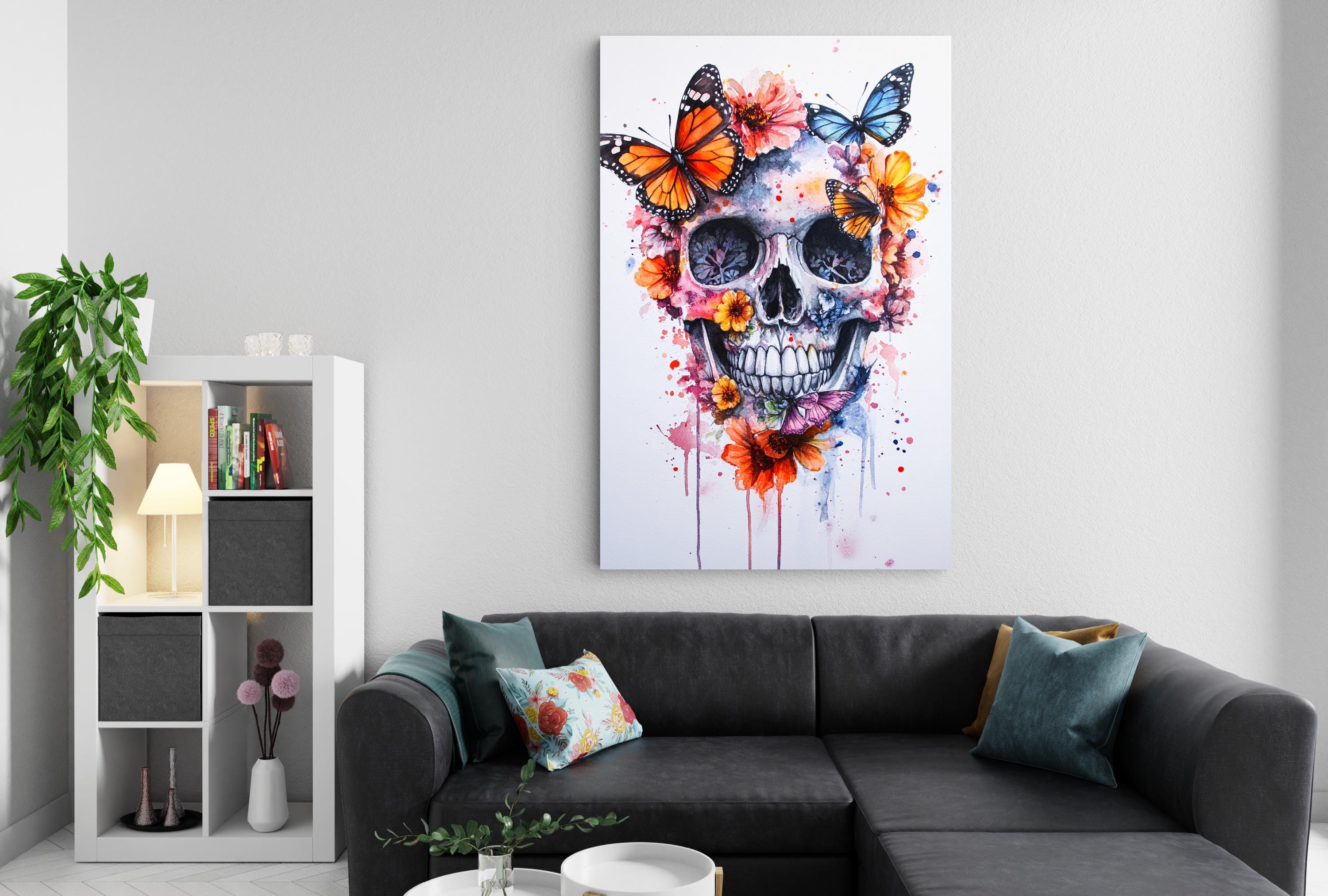 a living room with a black couch, a white bookshelf, and a large painting of a skull with colorful butterflies and flowers on the wall above it.