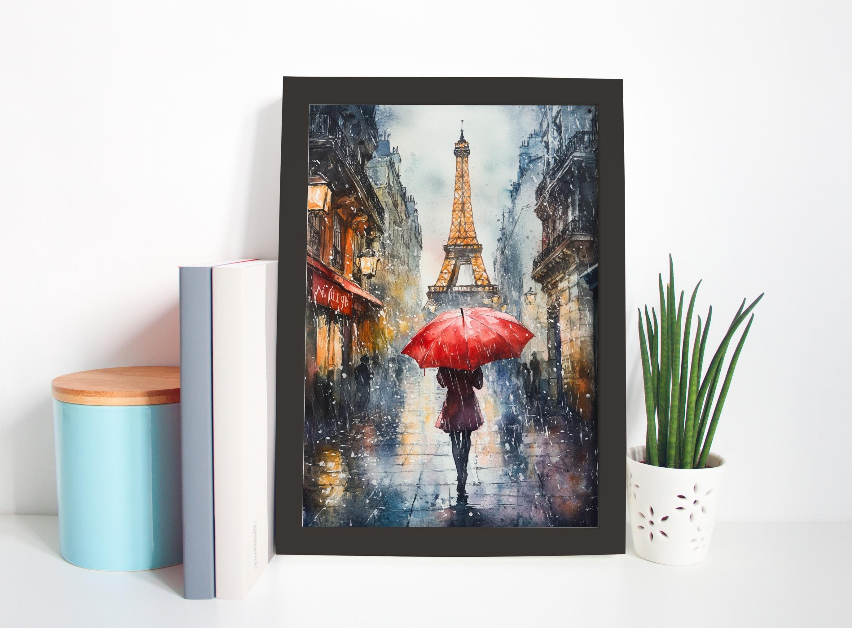 a framed painting of a woman walking with a red umbrella in front of the Eiffel Tower on a rainy day in Paris.