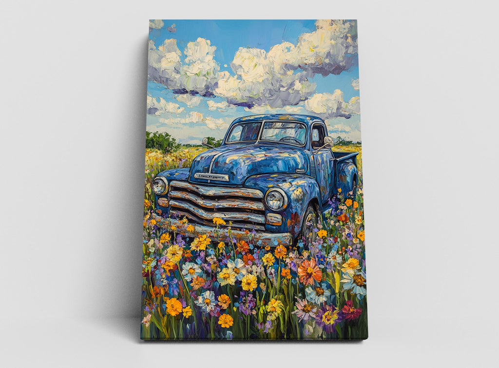 a blue truck parked in a field of colorful flowers, with a blue sky and fluffy white clouds in the background.