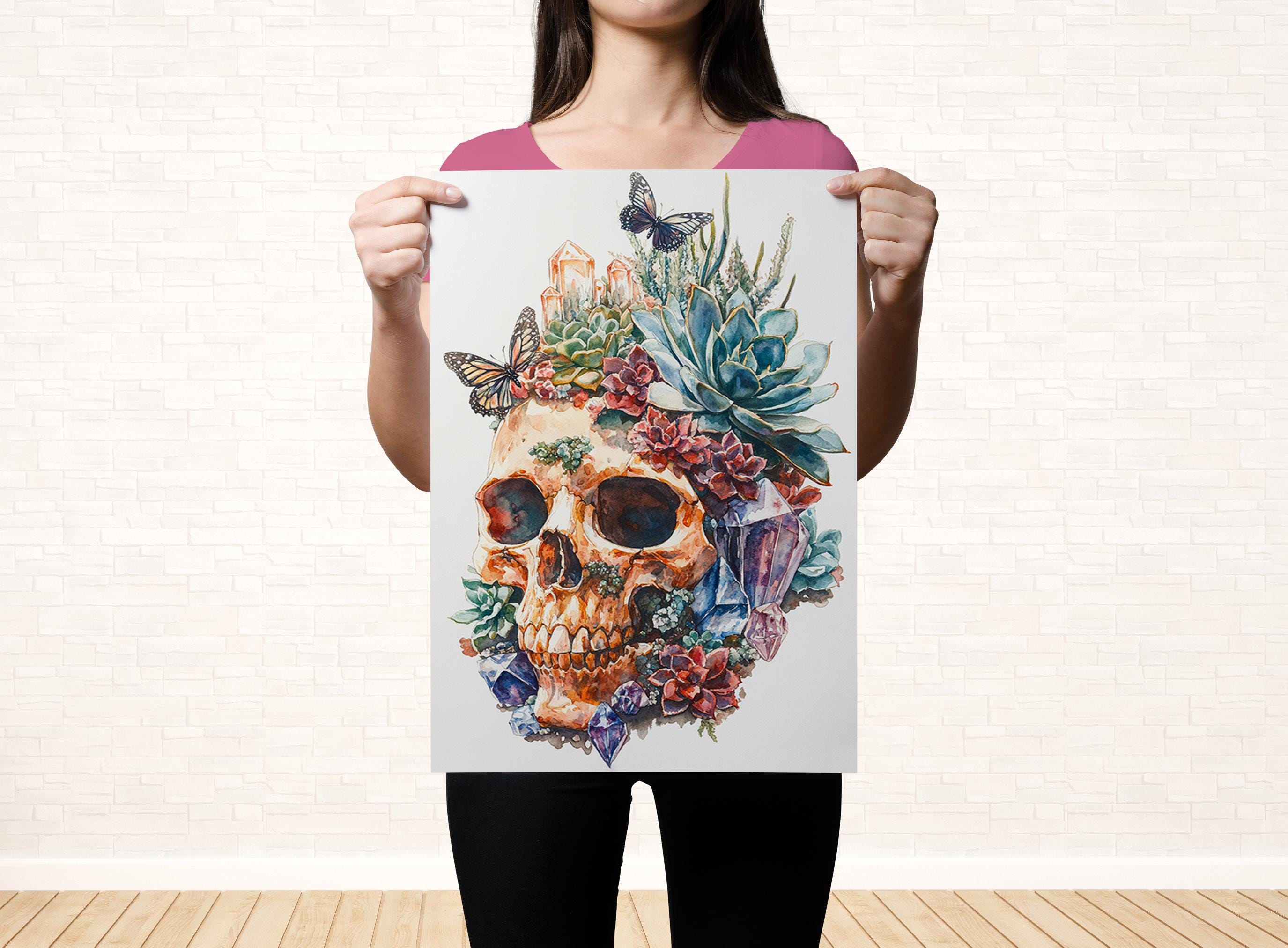 A woman holds up a poster featuring a colorful, artistic depiction of a skull surrounded by various floral and natural elements.