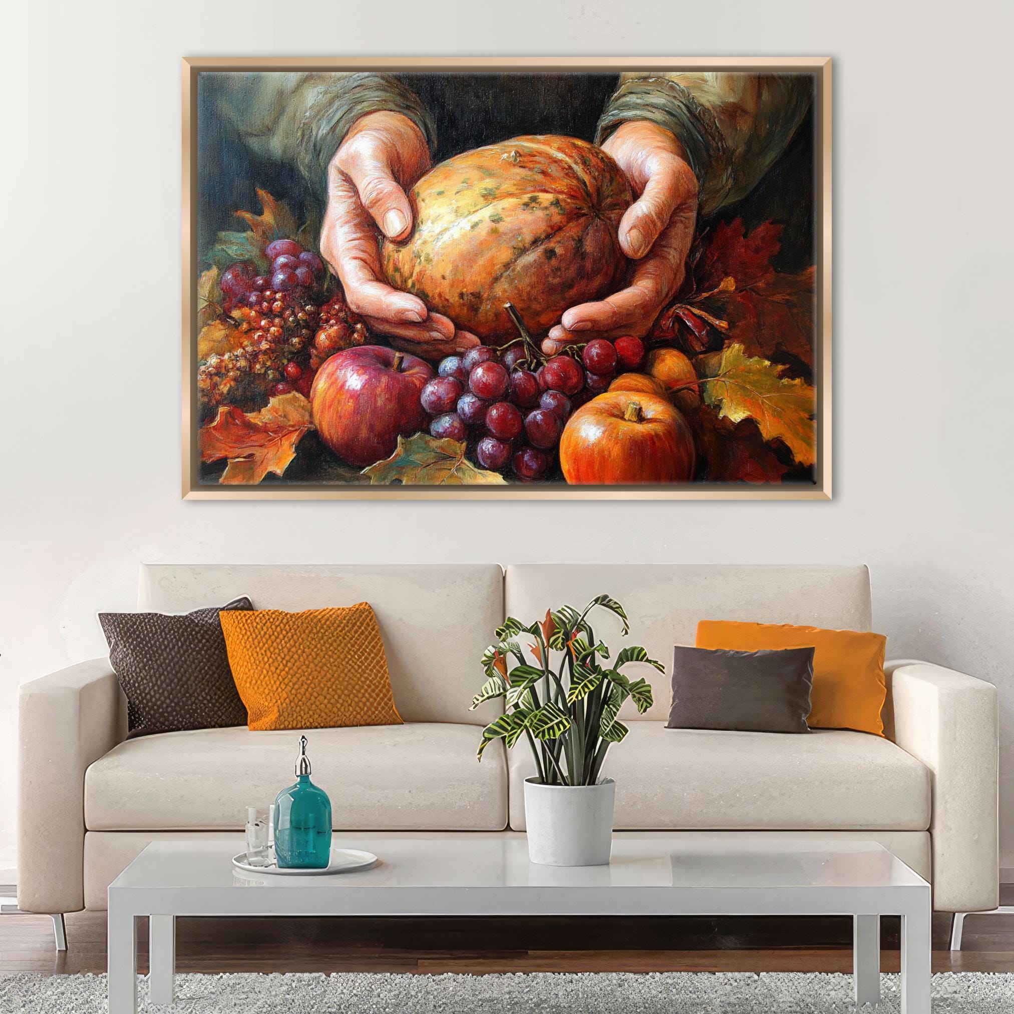 A cozy living room with a white sofa adorned with colorful throw pillows, a coffee table with a blue vase and a plant, and a framed painting of a pumpkin and autumn leaves hanging on the wall above the sofa.