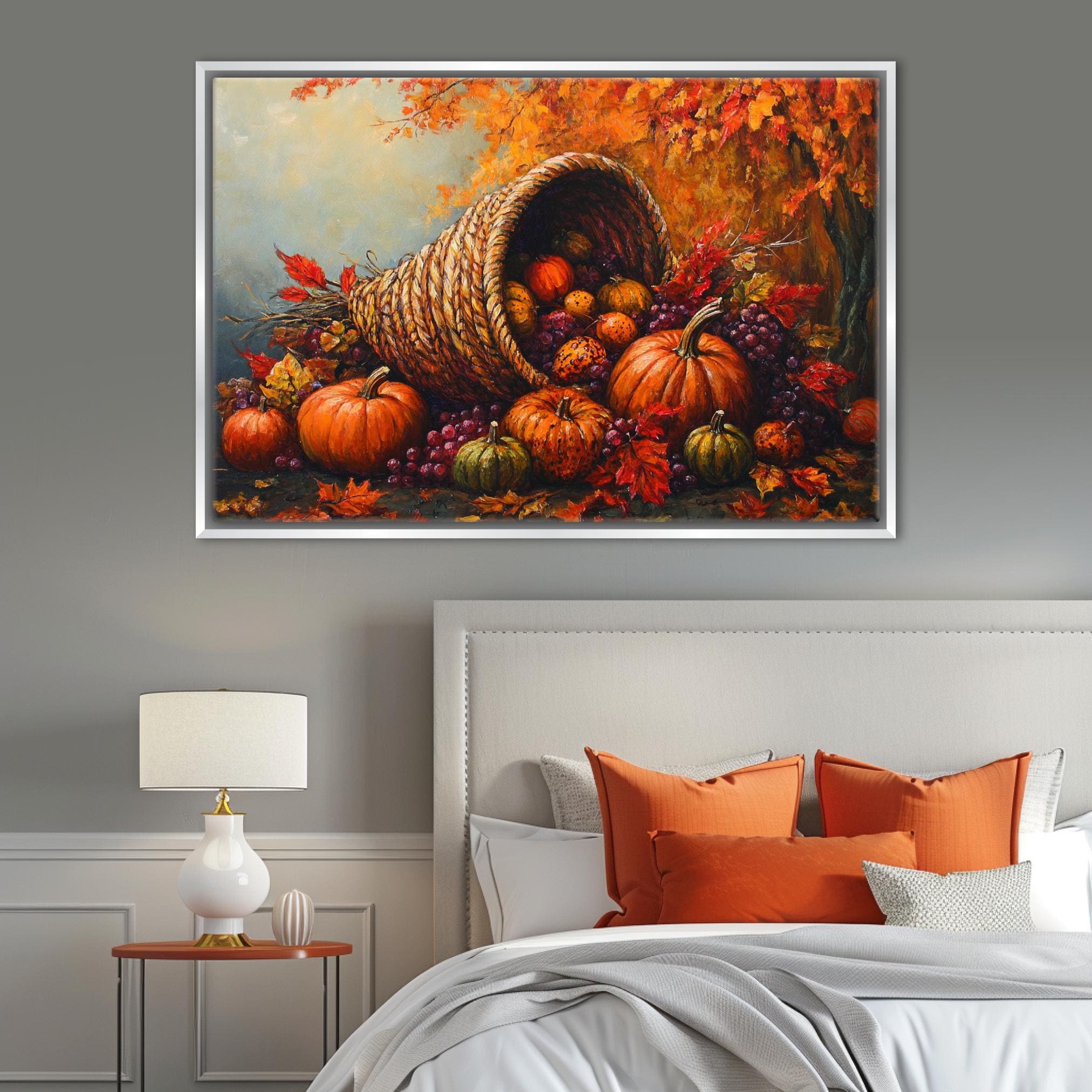 a cozy bedroom scene with a bed adorned with orange pillows and a white headboard. Above the bed, a large painting of a woven basket overflowing with autumn fruits, including pumpkins, gourds, and grapes, hangs on the wall.