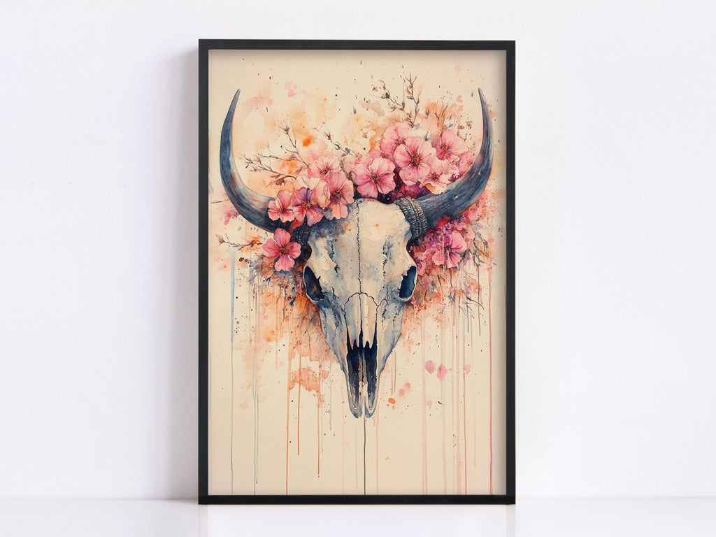 a framed artwork depicting a skull with large horns adorned with pink flowers.