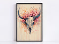 a framed artwork depicting a skull with large horns adorned with pink flowers.