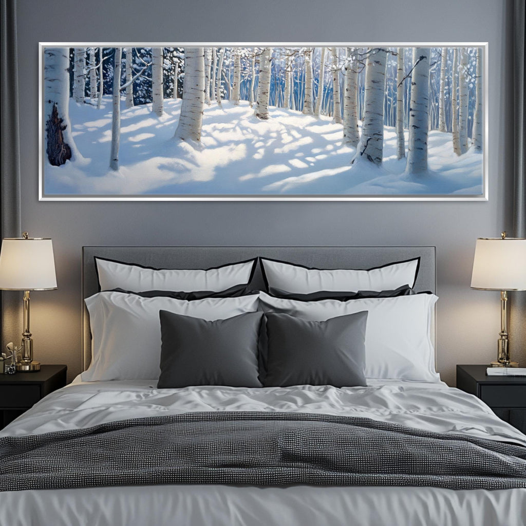 a large picture of a snowy forest hangs above a bed