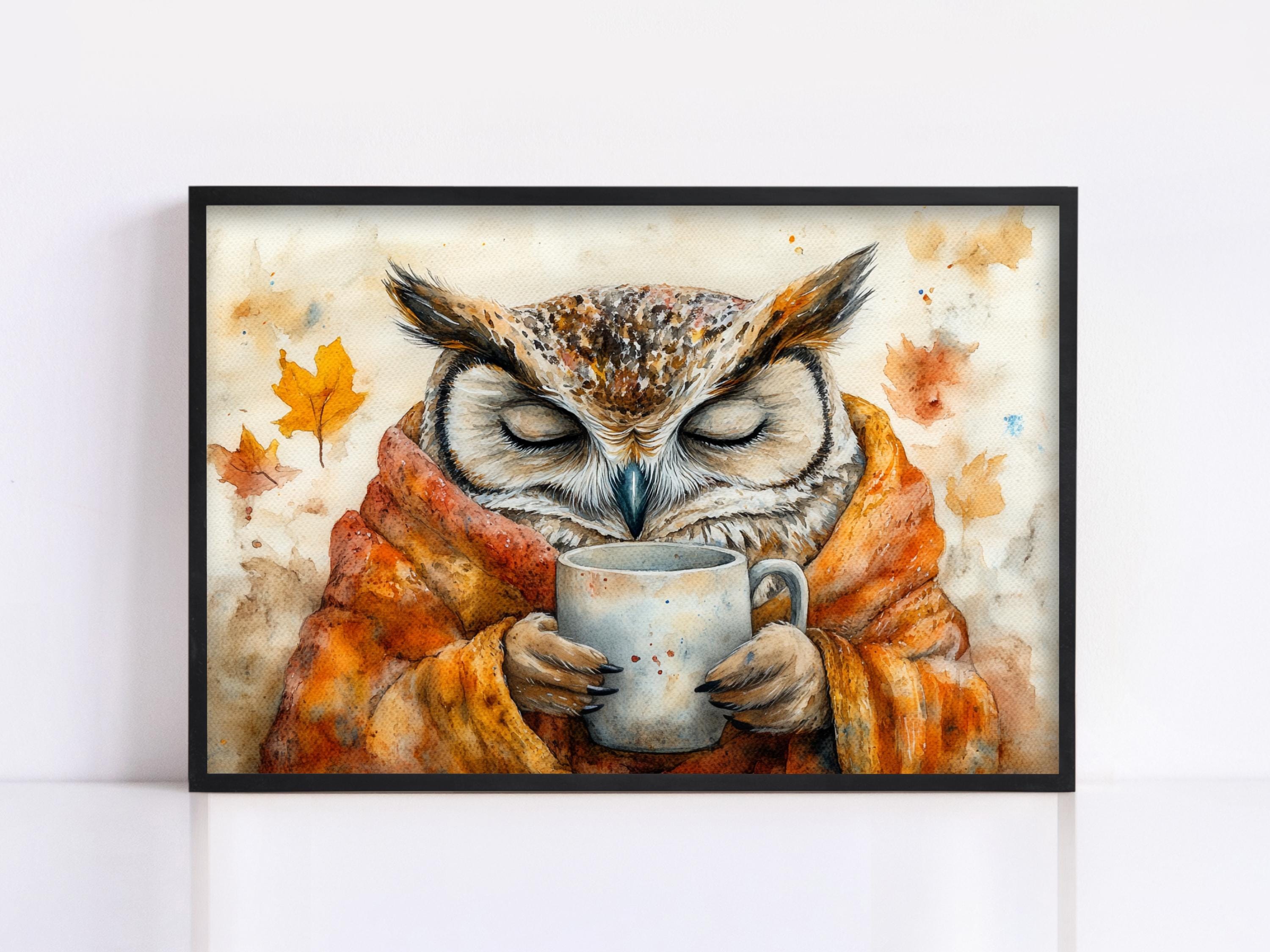 A framed painting depicting an owl wrapped in a blanket and holding a mug, with autumn leaves in the background.