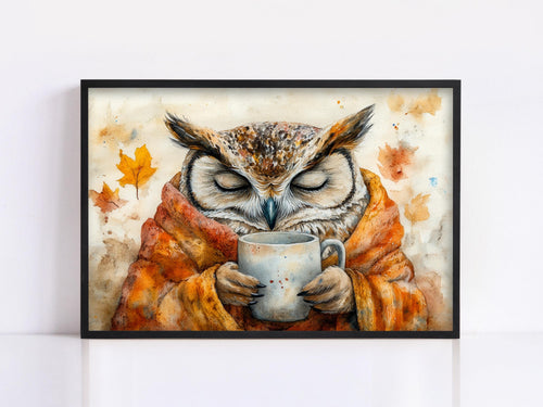 A framed painting depicting an owl wrapped in a blanket and holding a mug, with autumn leaves in the background.