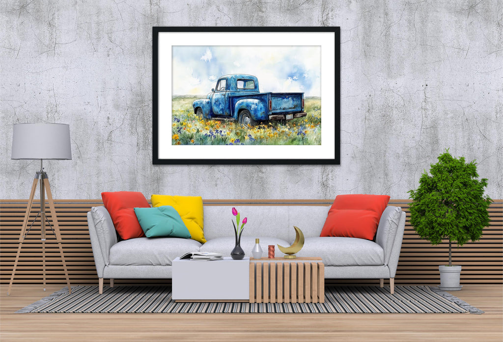 a cozy living room with a gray sofa adorned with colorful pillows, a wooden coffee table, and a framed painting of a blue truck in a field of flowers hanging on the wall above the sofa.