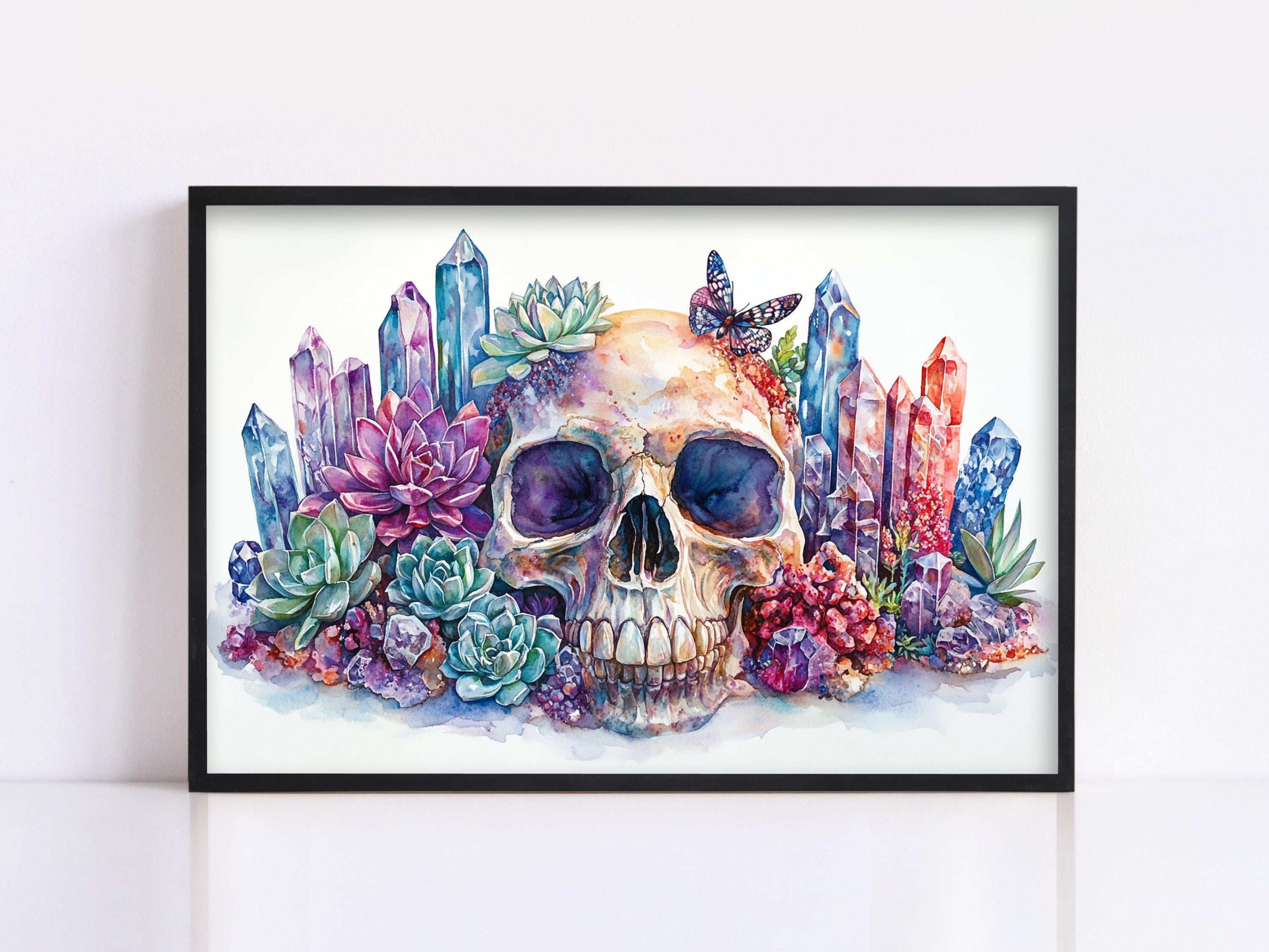 A framed watercolor painting depicting a skull surrounded by colorful crystals, succulents, and butterflies.