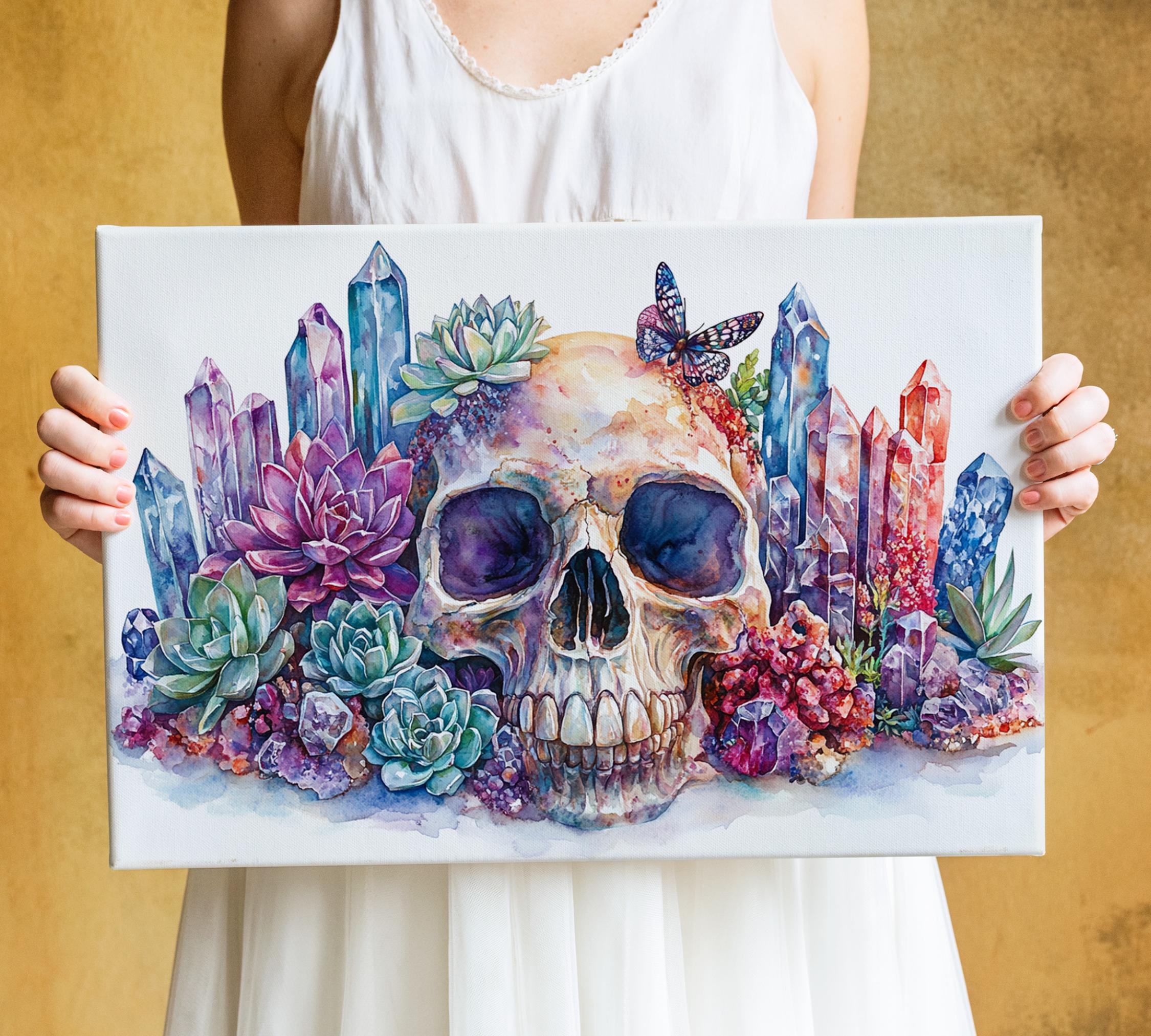 A person is holding a canvas with a colorful painting of a skull surrounded by various flowers, including succulents and other plants.