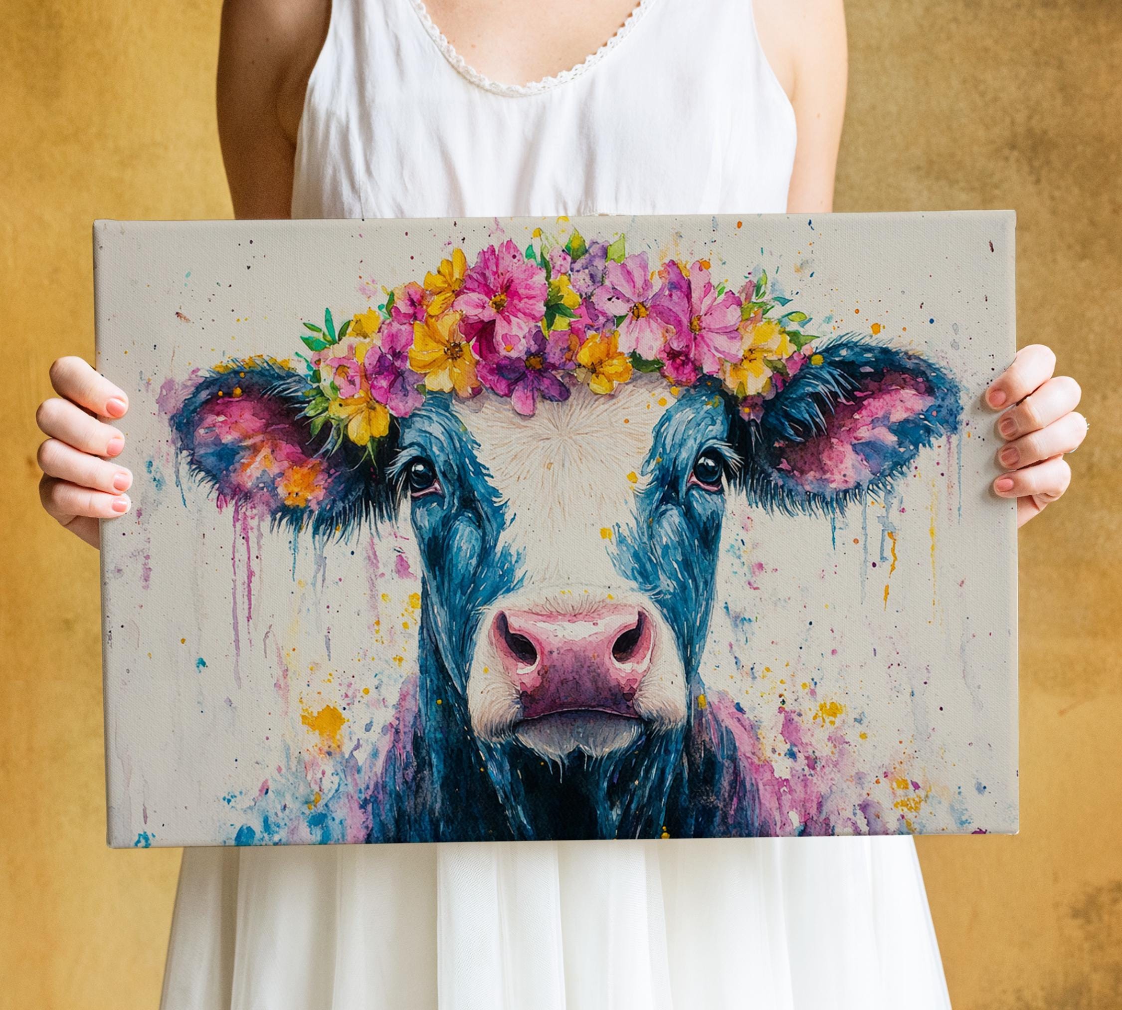 A woman holds a canvas featuring a cow with a flower crown on its head.