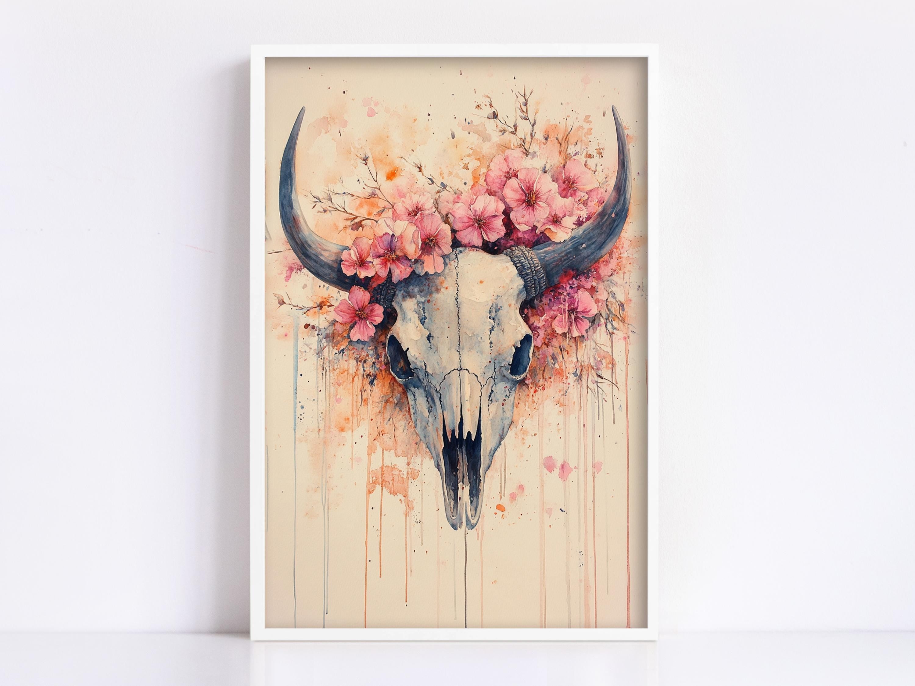 a framed painting of a skull adorned with pink flowers.