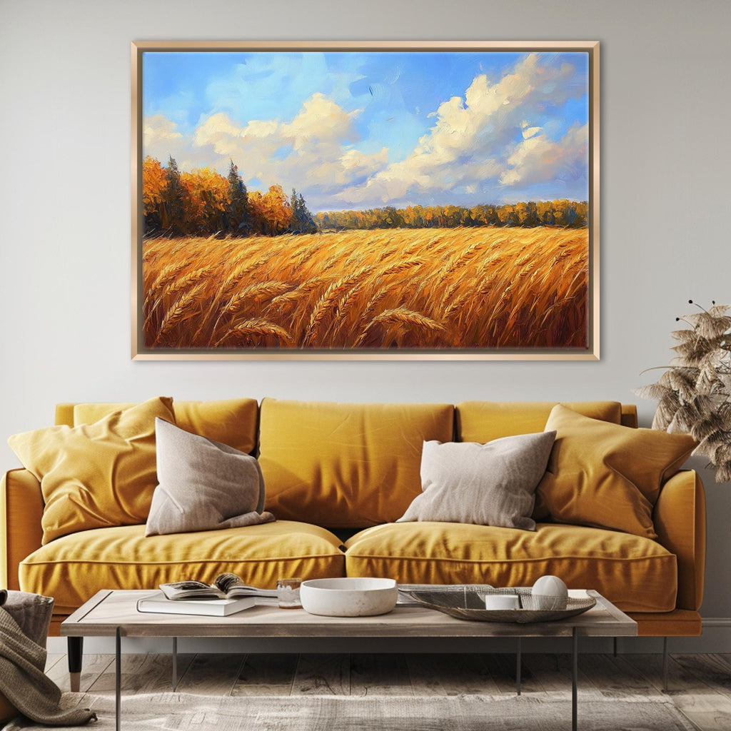 a large painting of a field of golden wheat against a blue sky with clouds, hanging on a wall above a yellow sofa with two pillows.