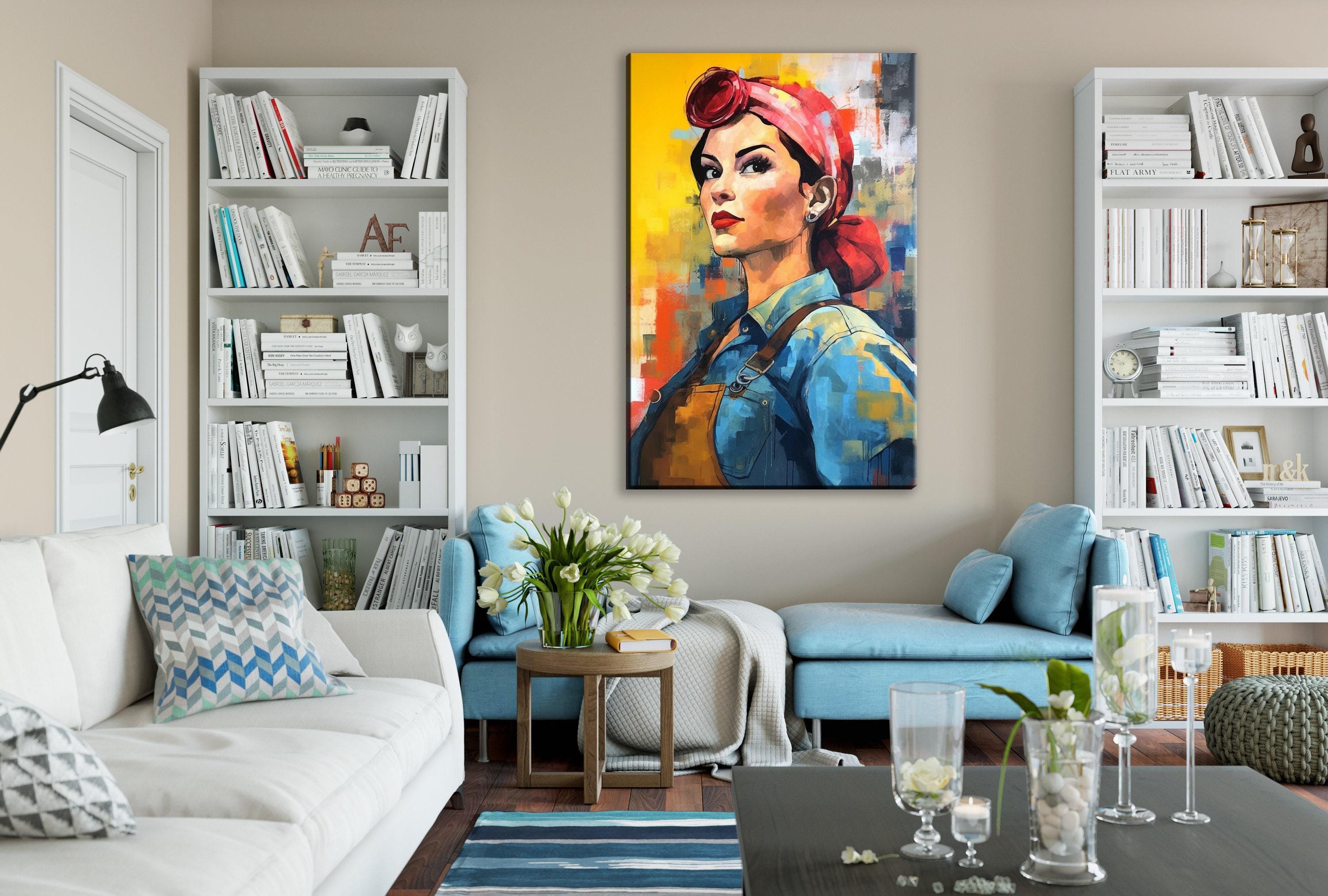 a cozy living room with a large, colorful painting of a woman's portrait hanging on the wall. The room is furnished with a white sofa, a blue armchair, and a wooden coffee table. The walls are adorned with numerous bookshelves filled with books, and the room is decorated with vases, candles, and other decorative items.