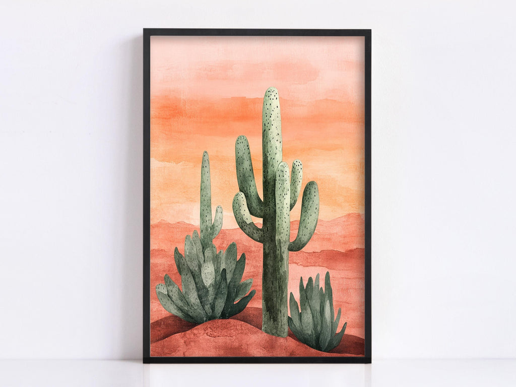 A framed watercolor painting depicting a desert landscape with three cacti against a warm, orange-red background.
