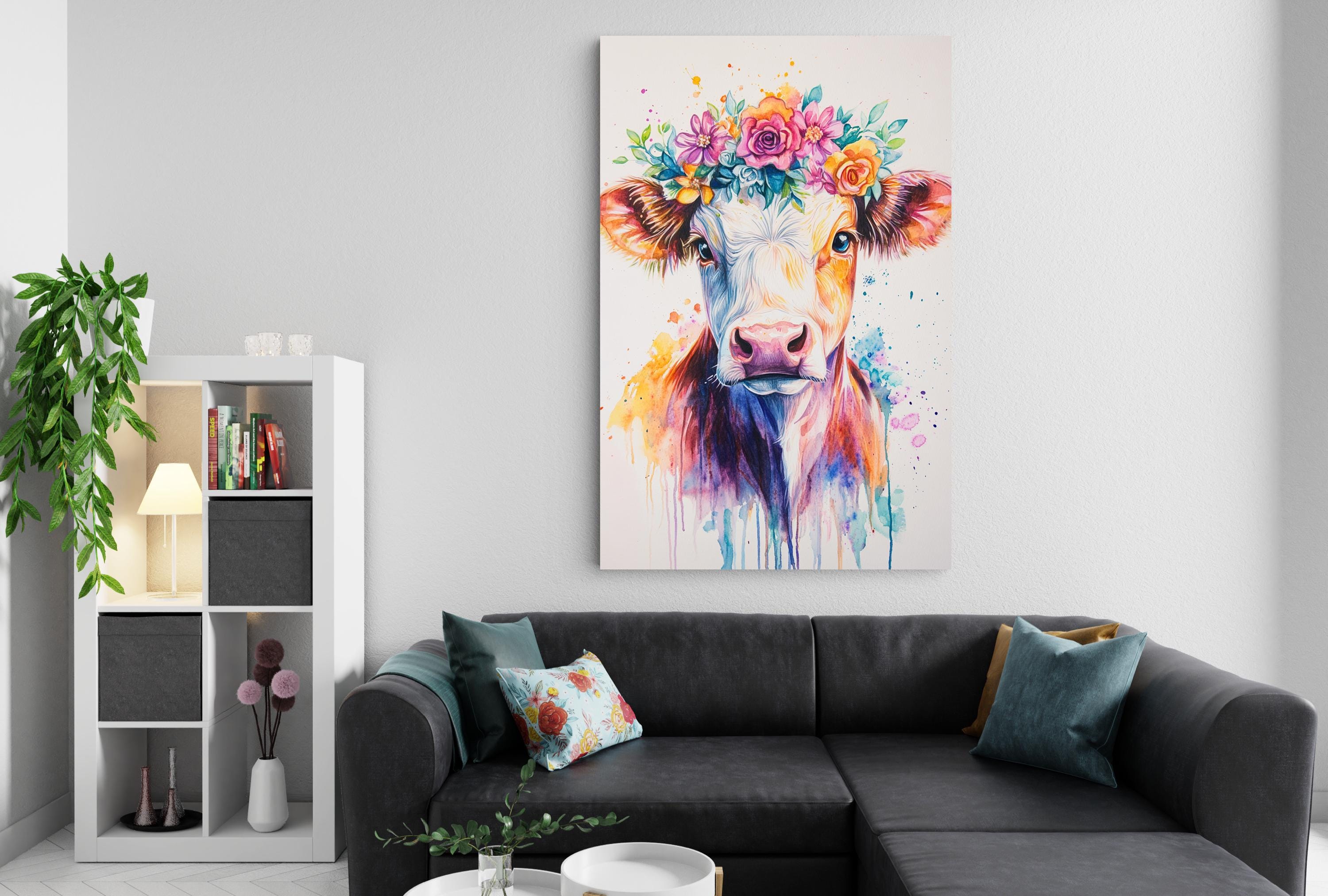 a living room with a black sectional sofa, a bookshelf, and a colorful painting of a cow with a flower crown on the wall.