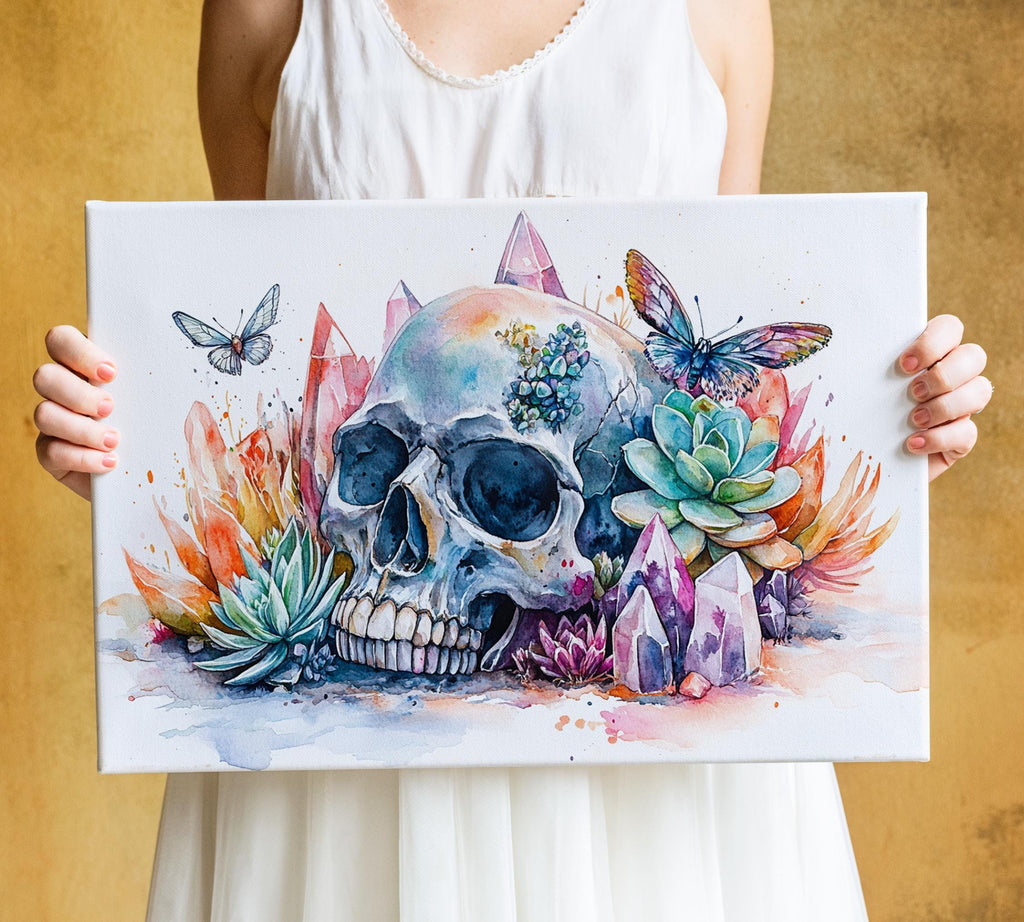 A person is holding a canvas with a colorful and intricate painting of a skull surrounded by various flowers, butterflies, and crystals.