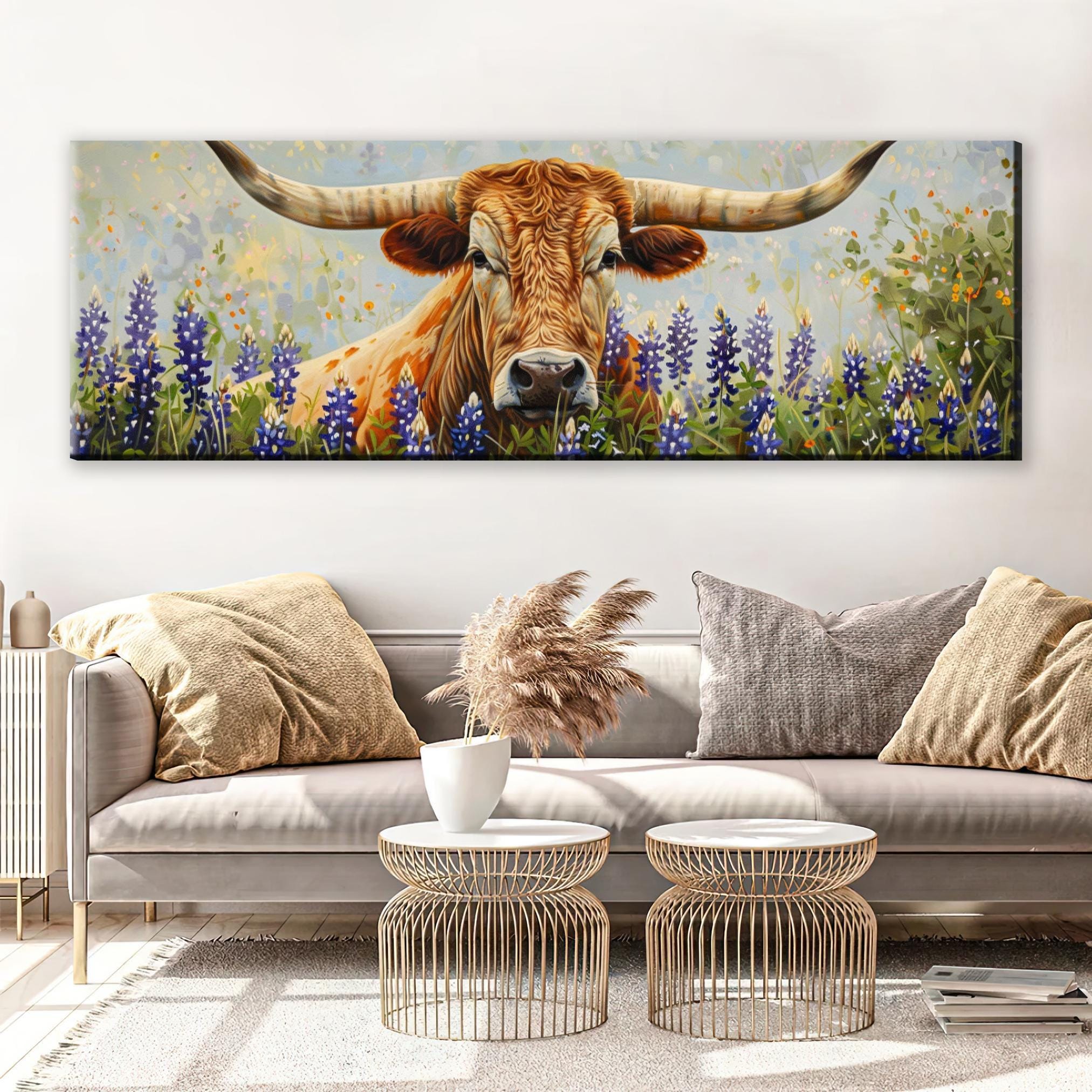 a large painting of a bull with long horns, surrounded by a field of purple flowers, hanging on a wall above a couch in a living room setting.