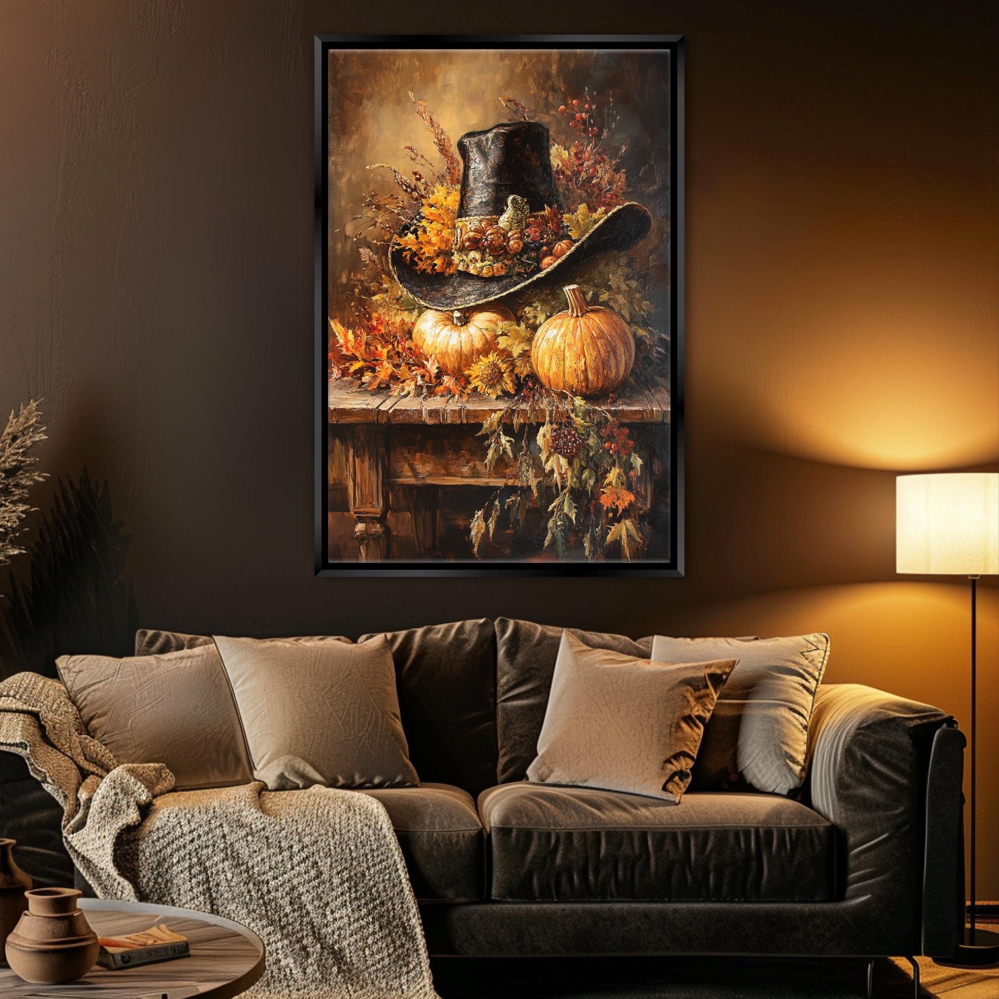 a cozy living room with a large framed painting of a cowboy hat and pumpkins hanging on the wall above a brown leather couch.