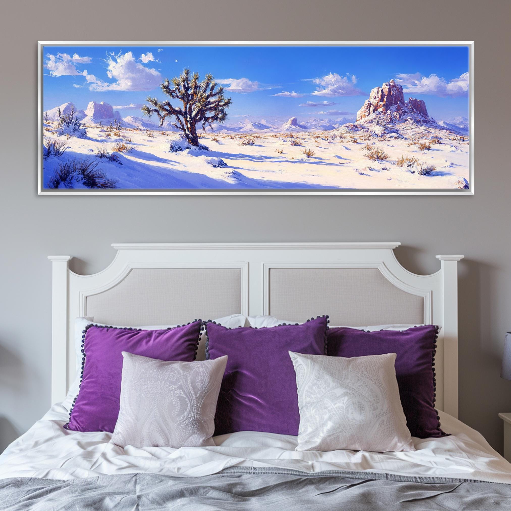 a painting of a desert scene on a wall above a bed
