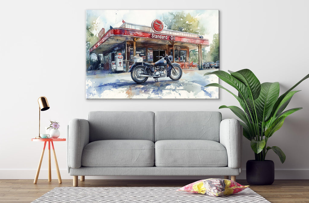 a gray sofa, a potted plant, and a painting of a gas station with a motorcycle on display.