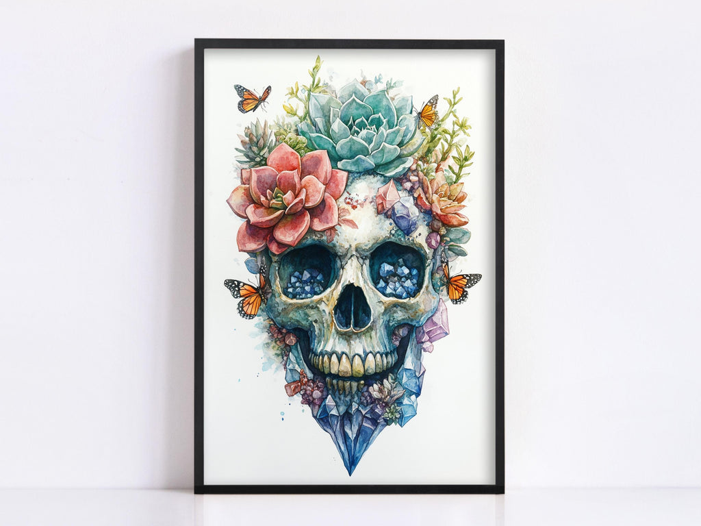 a framed artwork depicting a skull adorned with a floral arrangement, including a cactus, succulents, and colorful flowers.