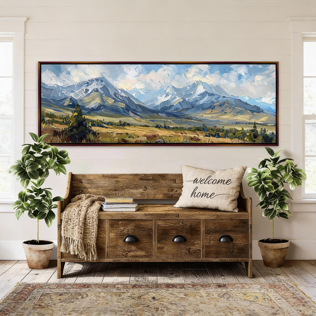 a large wooden bench with a "welcome home" pillow, surrounded by potted plants and a large landscape painting hanging on the wall above it.