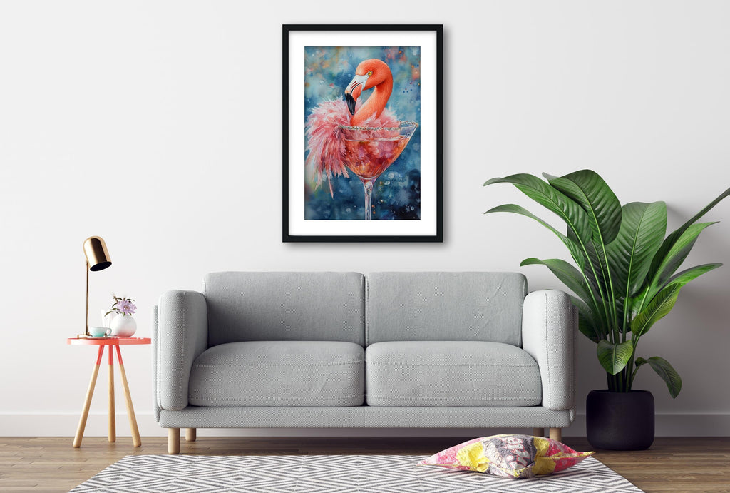 a gray sofa, a framed painting of a flamingo in a martini glass, a small table with a lamp, and a potted plant.