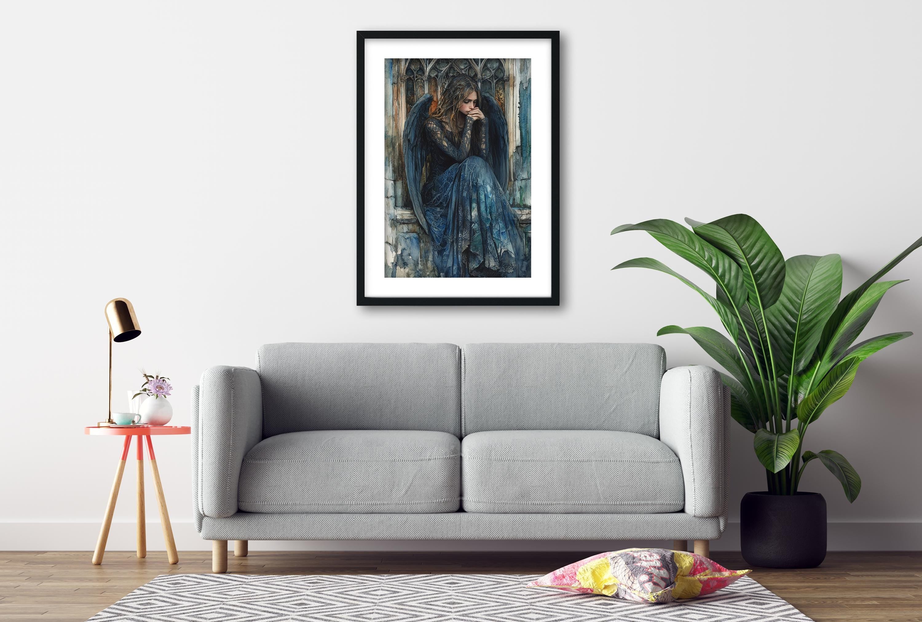 a gray sofa, a framed painting of a woman in a blue dress, a small table with a lamp, and a potted plant, all arranged in a living room setting.