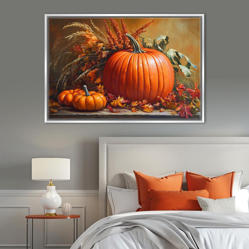 a large framed painting of a pumpkin and other fall-themed decorations hanging on a wall above a bed with orange pillows and a white headboard.
