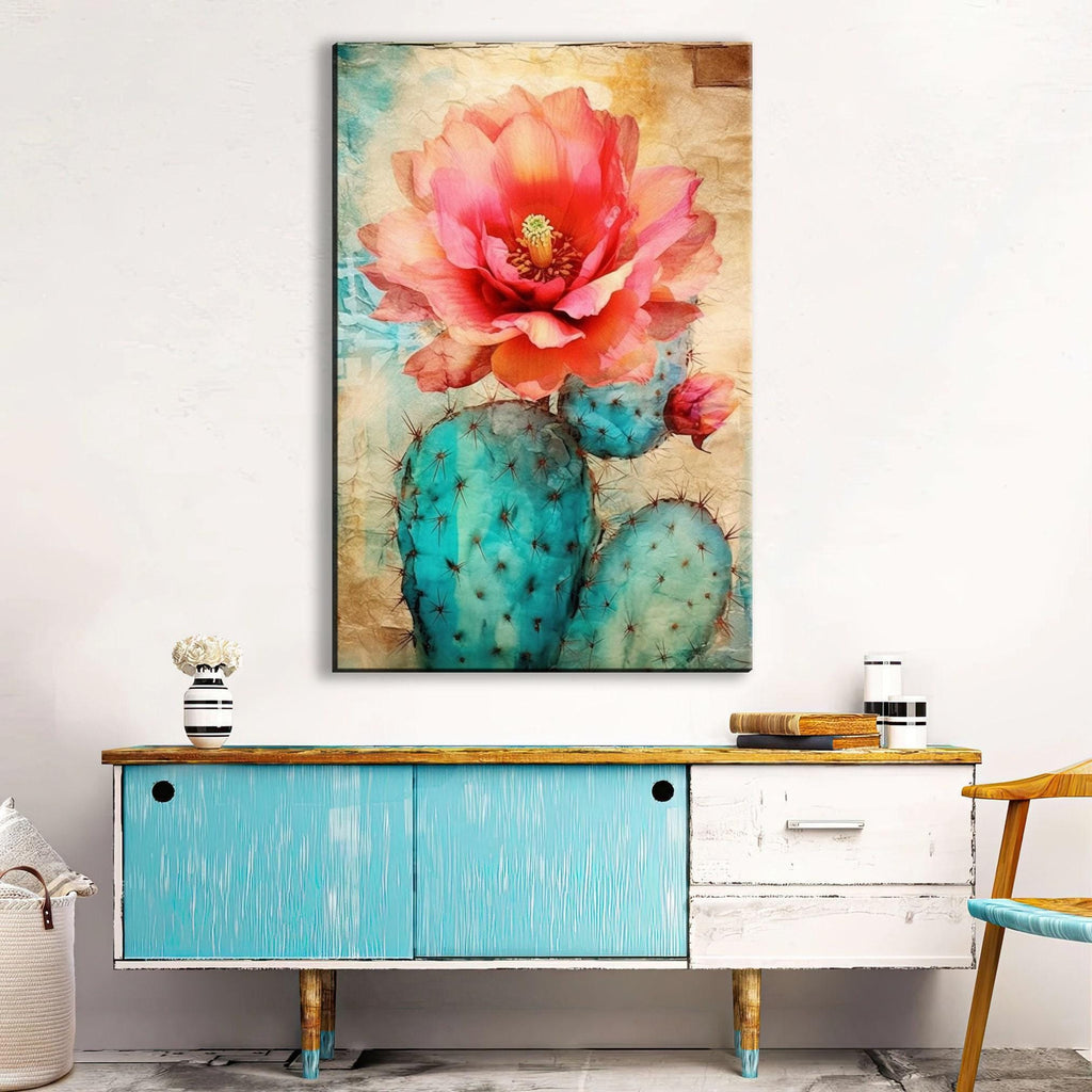 a vibrant painting of a cactus with a large pink flower on its top, hanging on a wall above a blue cabinet with a wooden top.