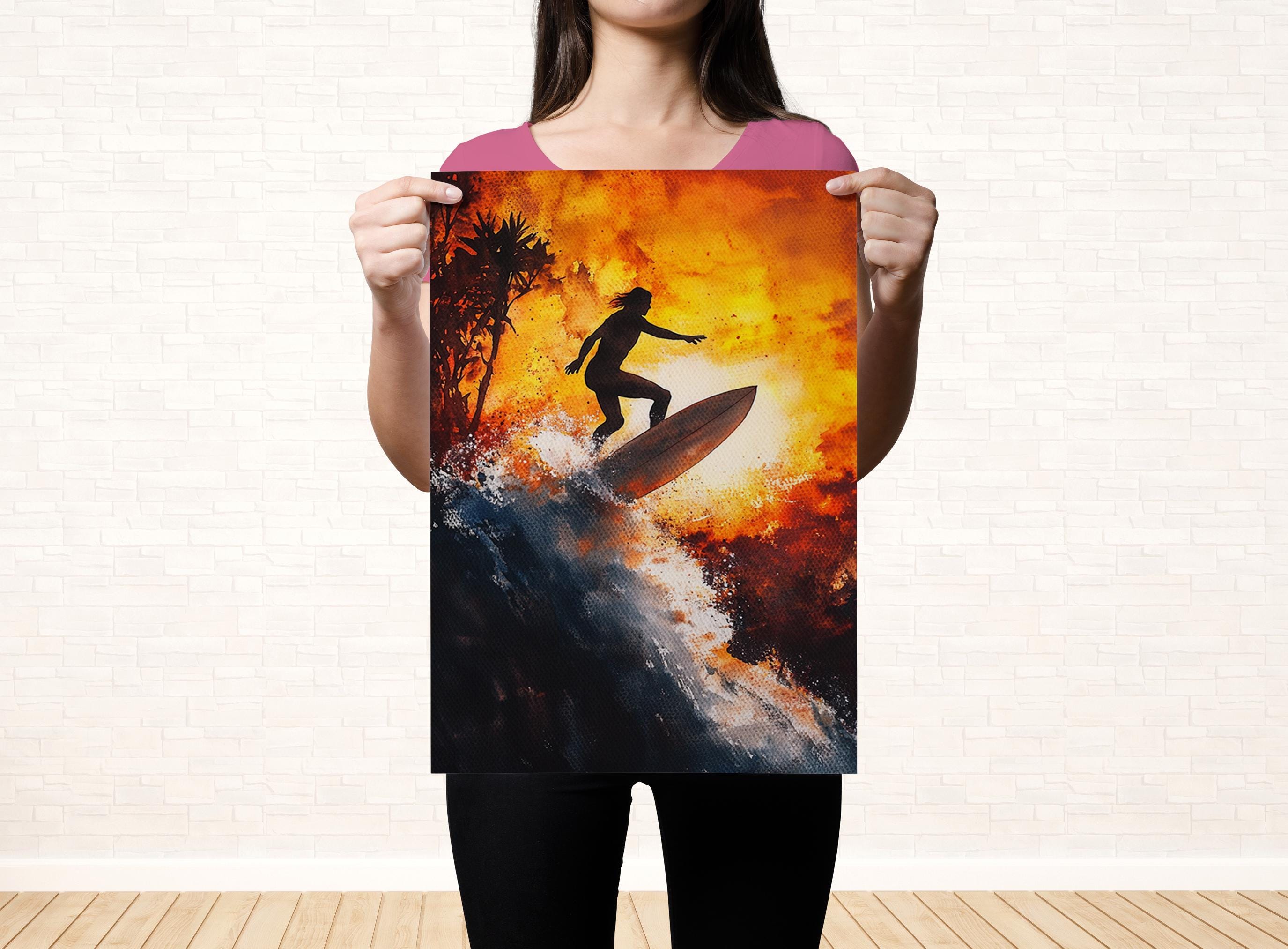 A woman holds up a framed print of a surfer riding a wave, with a fiery sunset in the background.