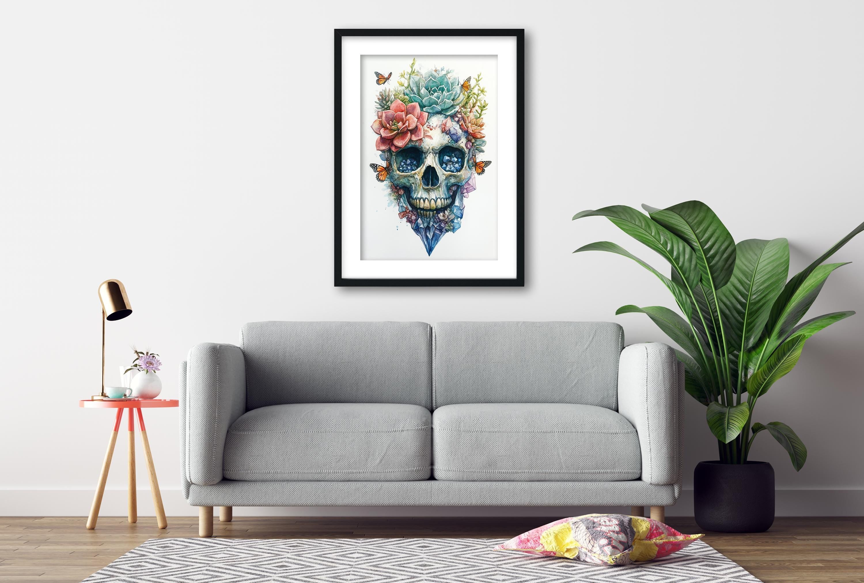 a gray sofa, a framed artwork of a colorful skull with flowers and butterflies, a small table with a lamp, and a potted plant.