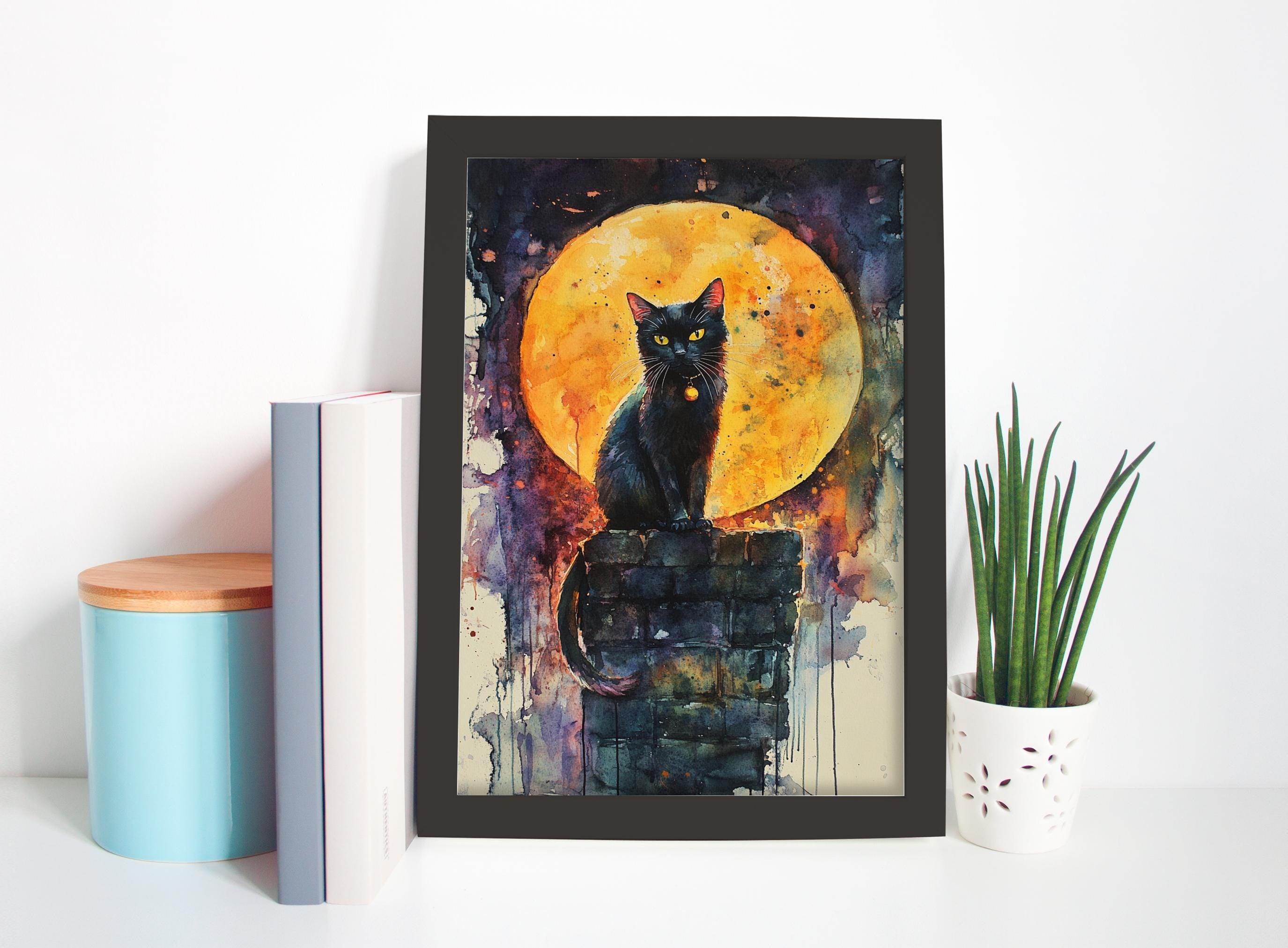 A framed painting of a black cat sitting on a brick wall, with a large orange and yellow moon in the background.