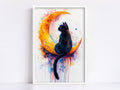 A framed painting depicting a black cat sitting on a crescent moon, with splashes of color surrounding the cat and moon.