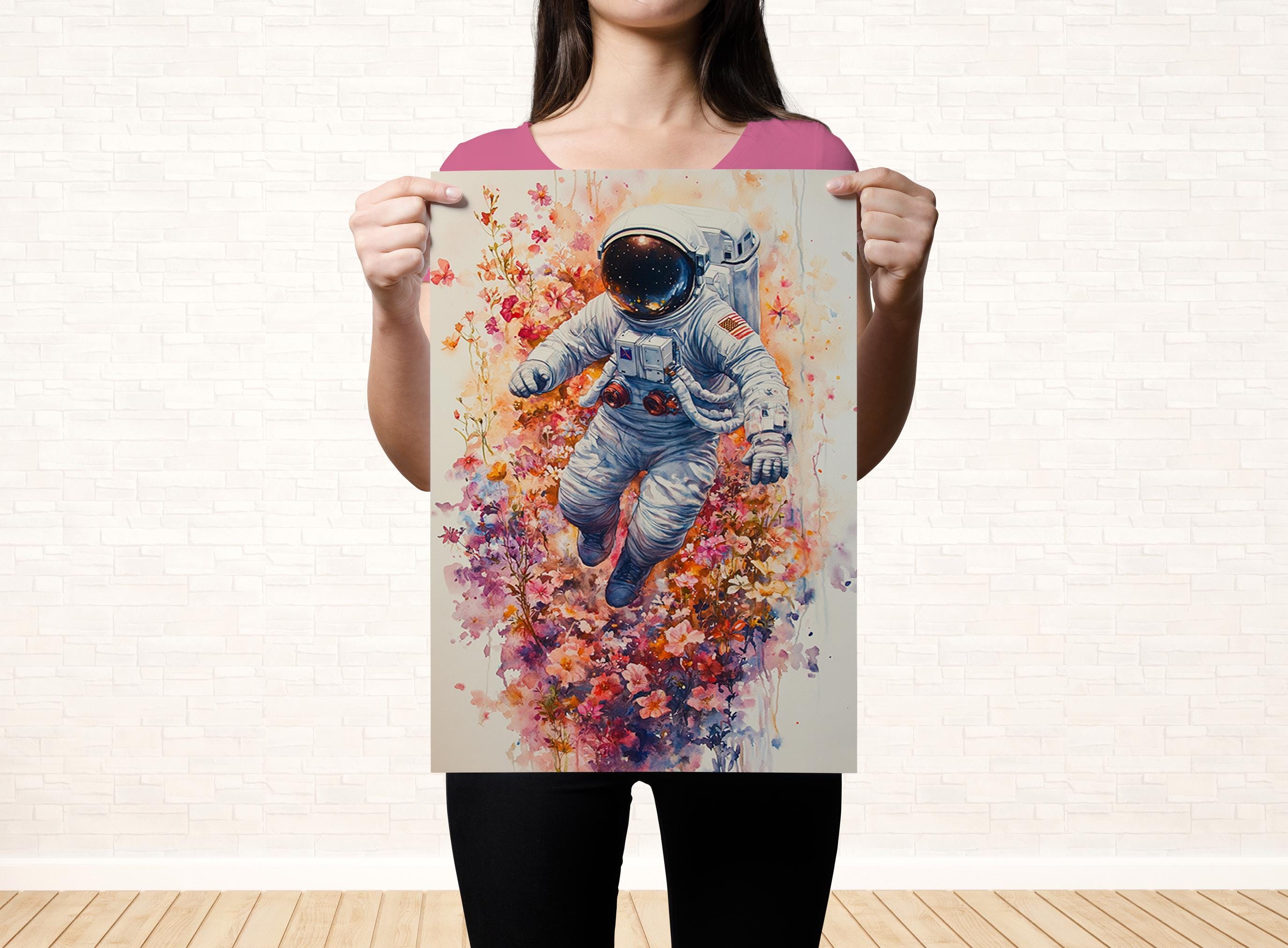 A woman holds up a poster featuring an astronaut floating in a colorful, floral-filled space.