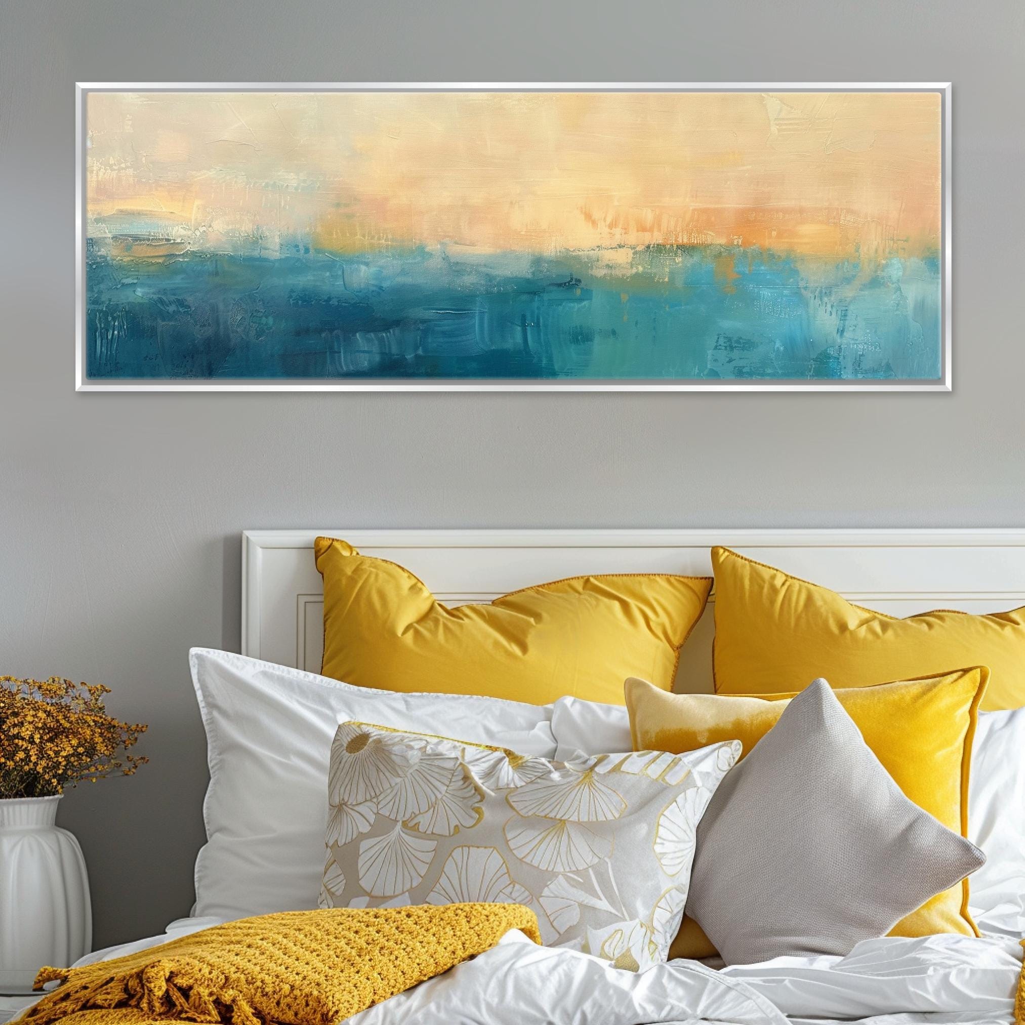 a bed with yellow and white pillows and a painting on the wall