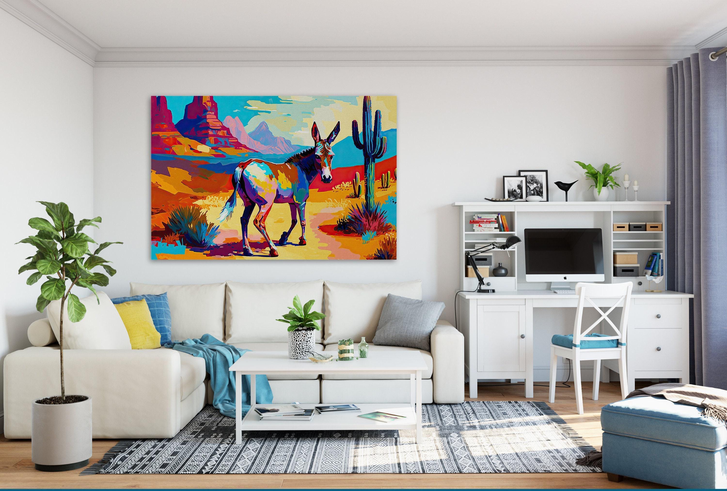 a modern living room with a large, colorful painting of a donkey in the desert hanging on the wall. The room is furnished with a white sofa, a coffee table, and a desk with a computer setup. The room also features a potted plant, a vase, and a bookshelf, creating a cozy and inviting atmosphere.