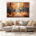 a large painting of a forest path with autumn trees, hanging on a wall above a gray sofa with two round coffee tables in front of it.