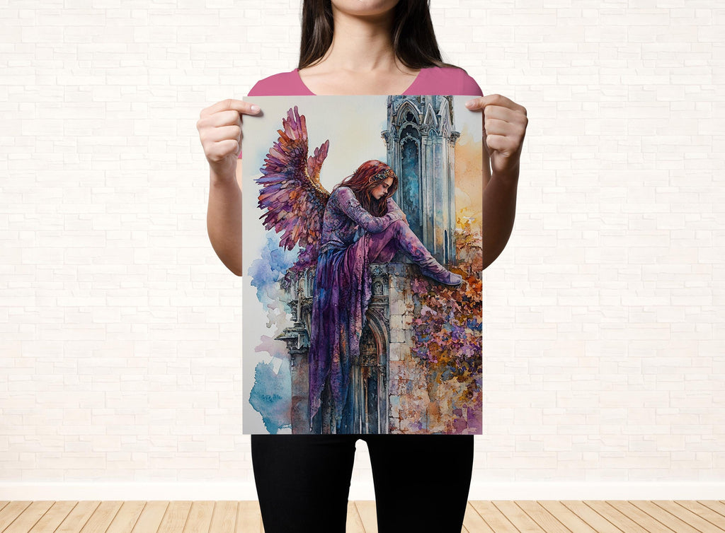 A woman holds up a colorful painting depicting a winged figure against a backdrop of a brick wall.