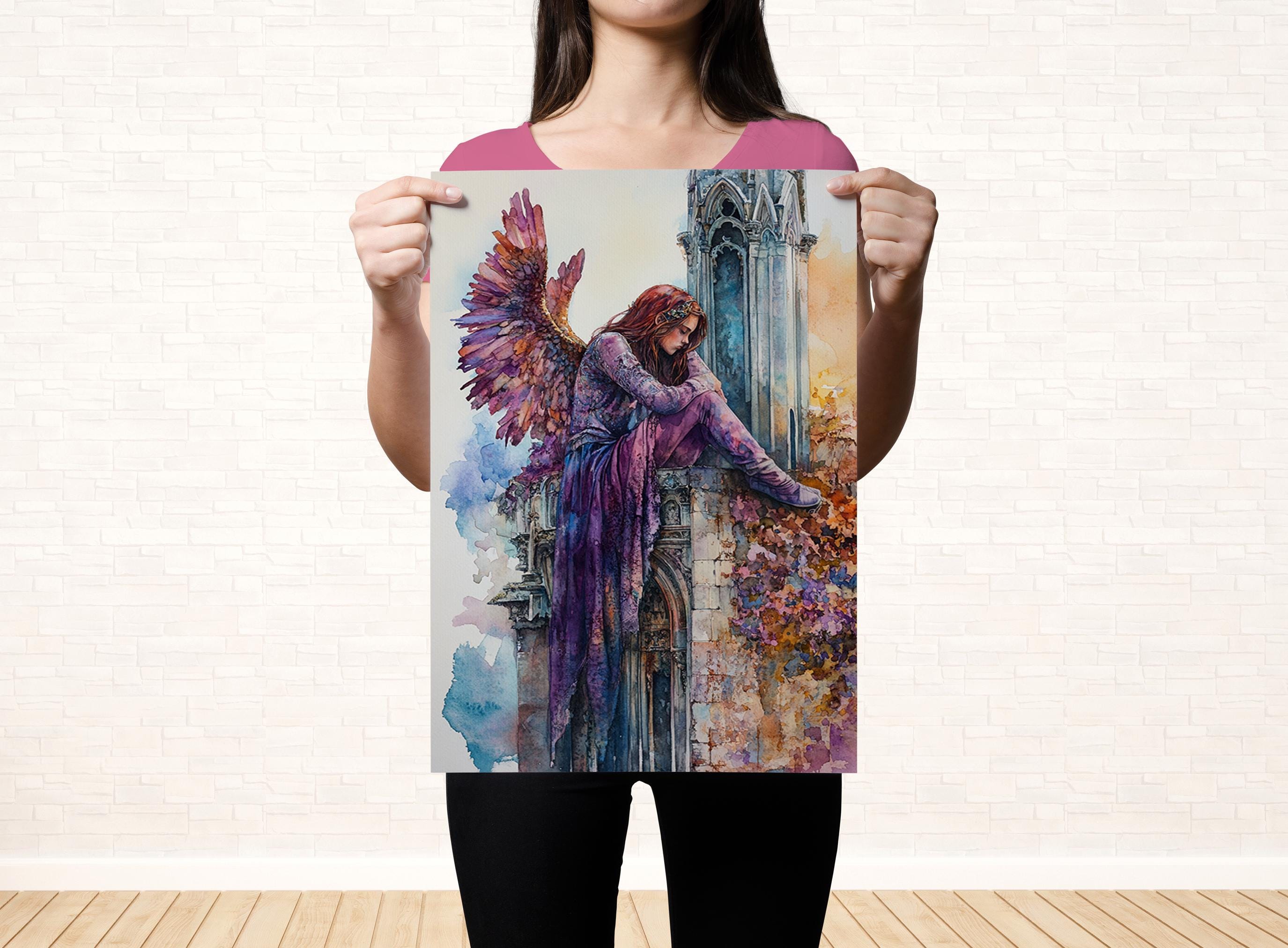 A woman holds up a colorful painting depicting a winged figure against a backdrop of a brick wall.